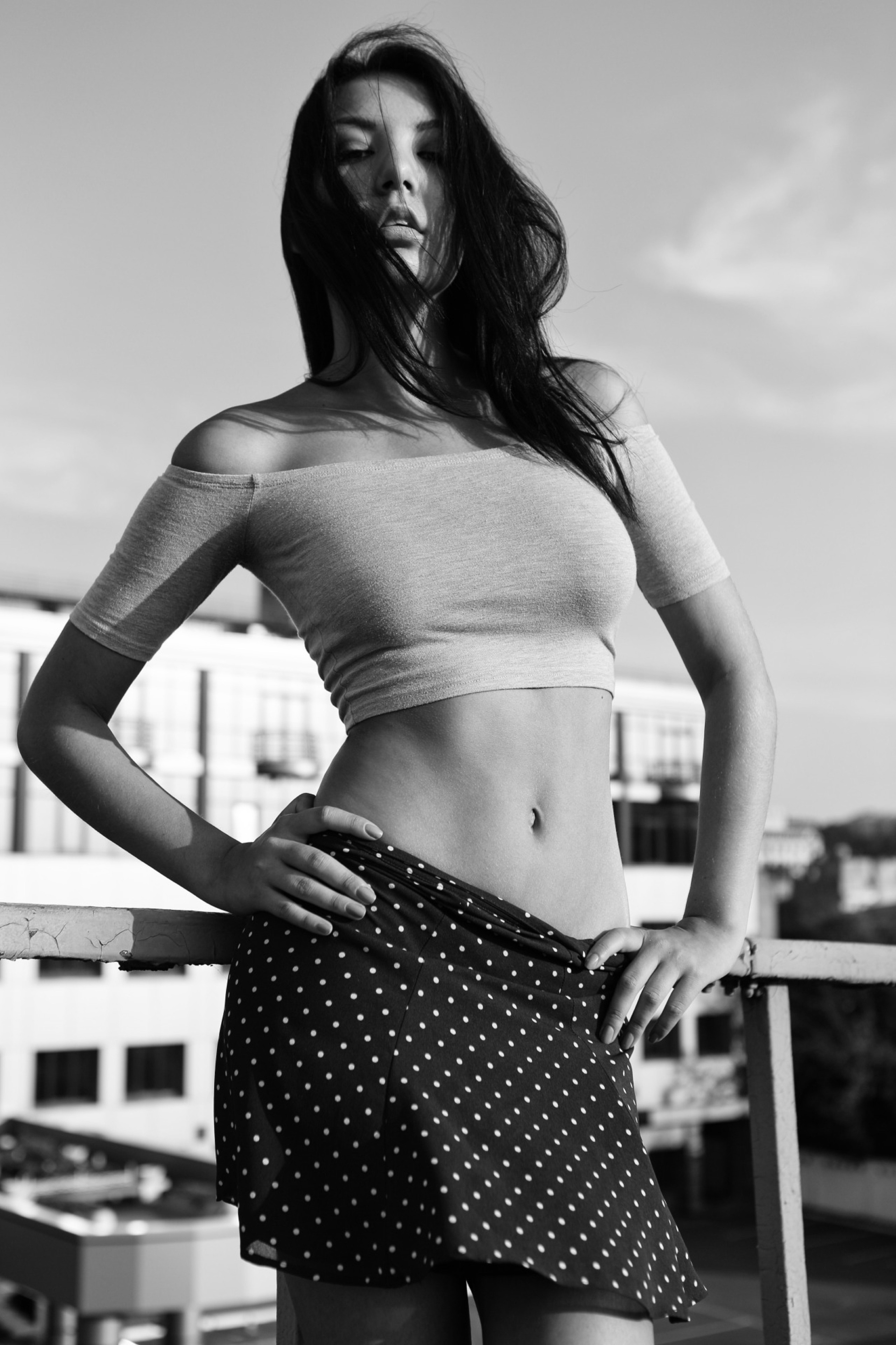 Портрет стройной девушки в топике и юбке в горошек на фоне промзоны в Киеве