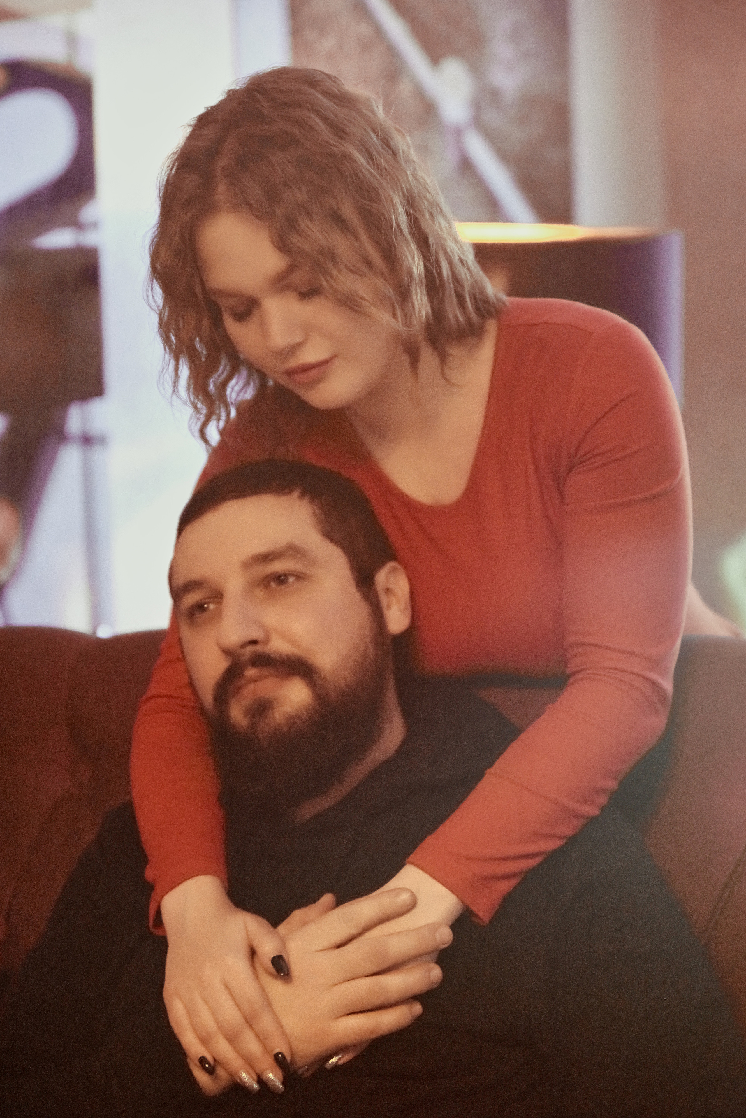 Девушка обнимает парня в кафе.