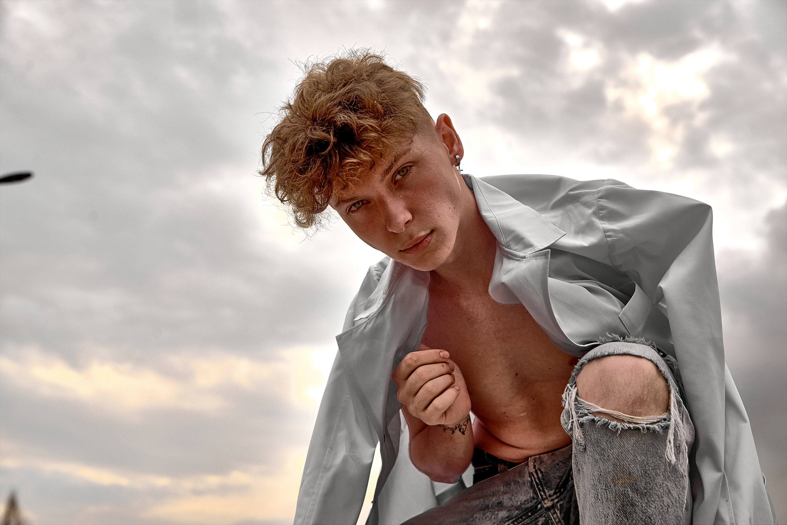 Фесшн портрет парня на фоне темных облаков, крупный план.