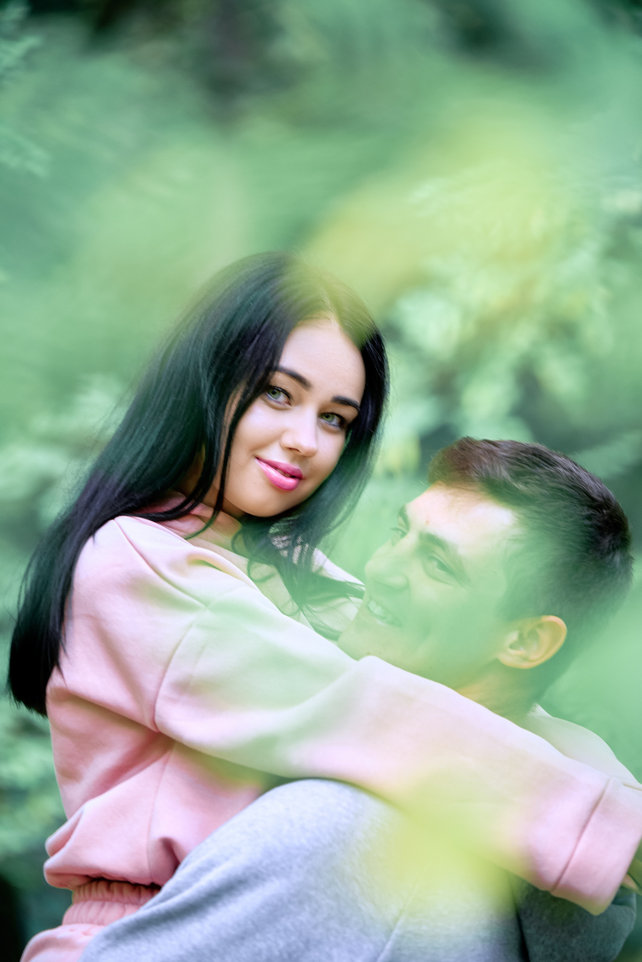 Лав стори, влюбленная парочка обнимается в зеленой листве.