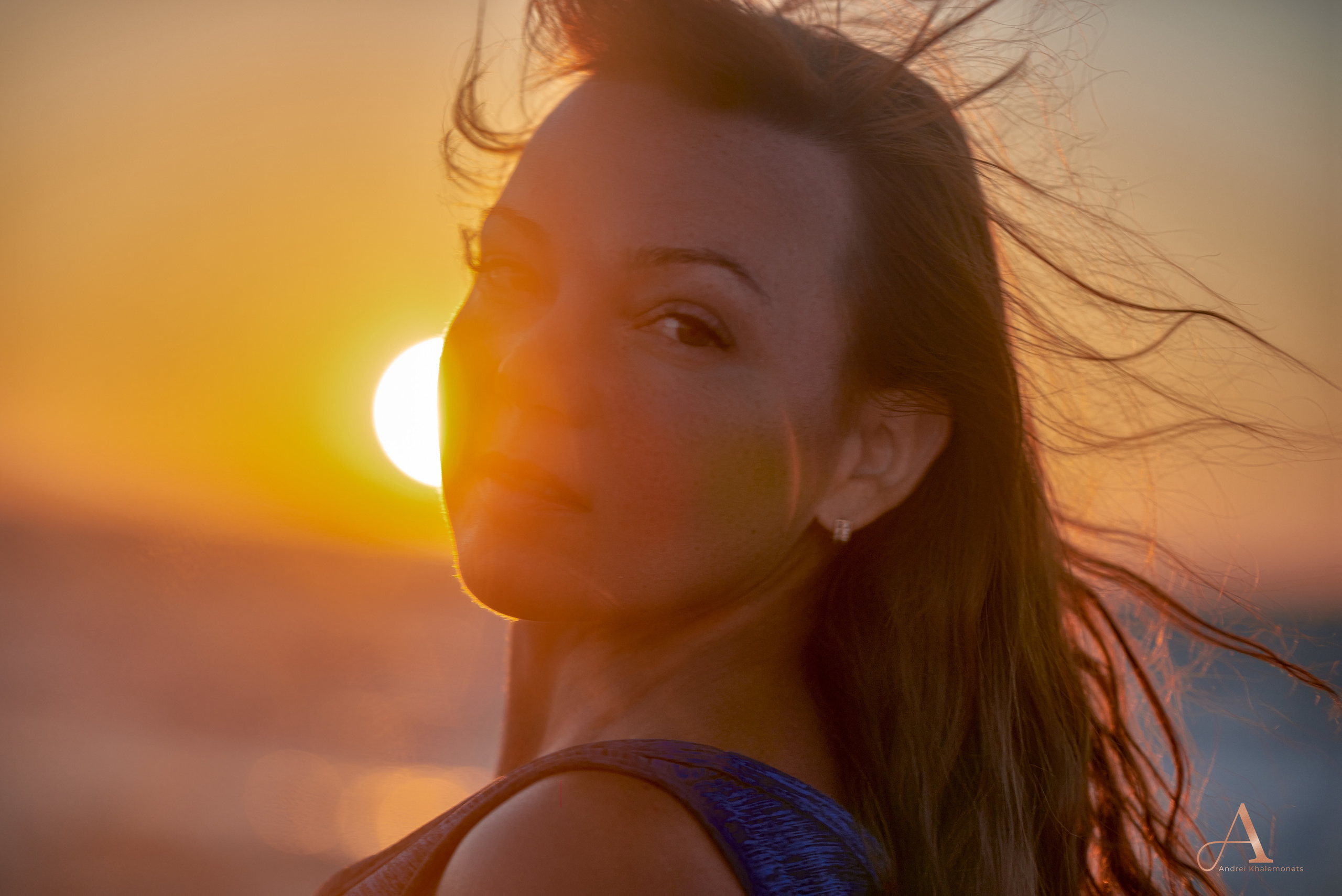 Портрет девушки на закате у моря, крупный план, контровой свет.