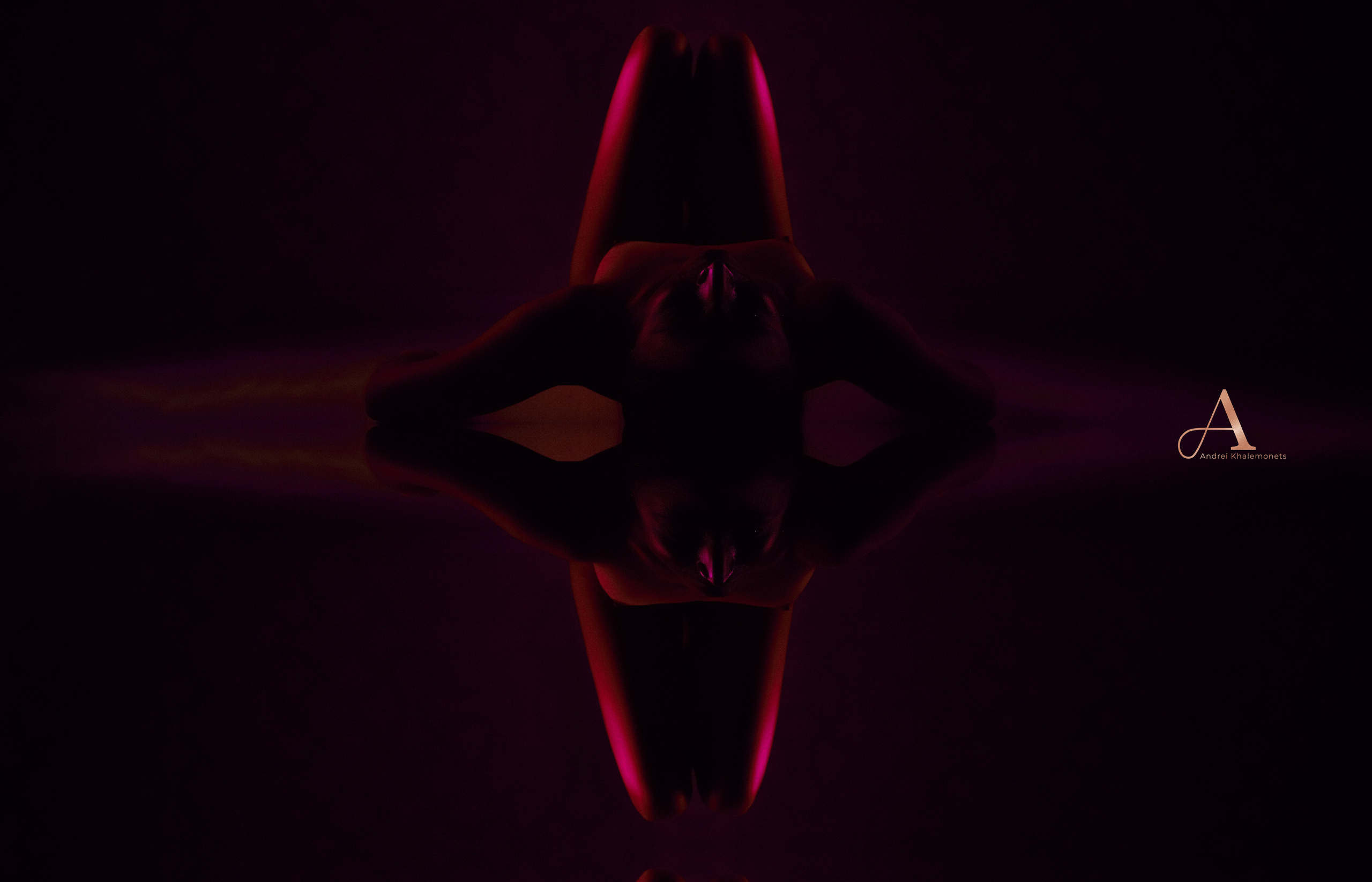 Обнаженная девушка лежит зеркальной поверхности, ню фотосессия в низком ключе.