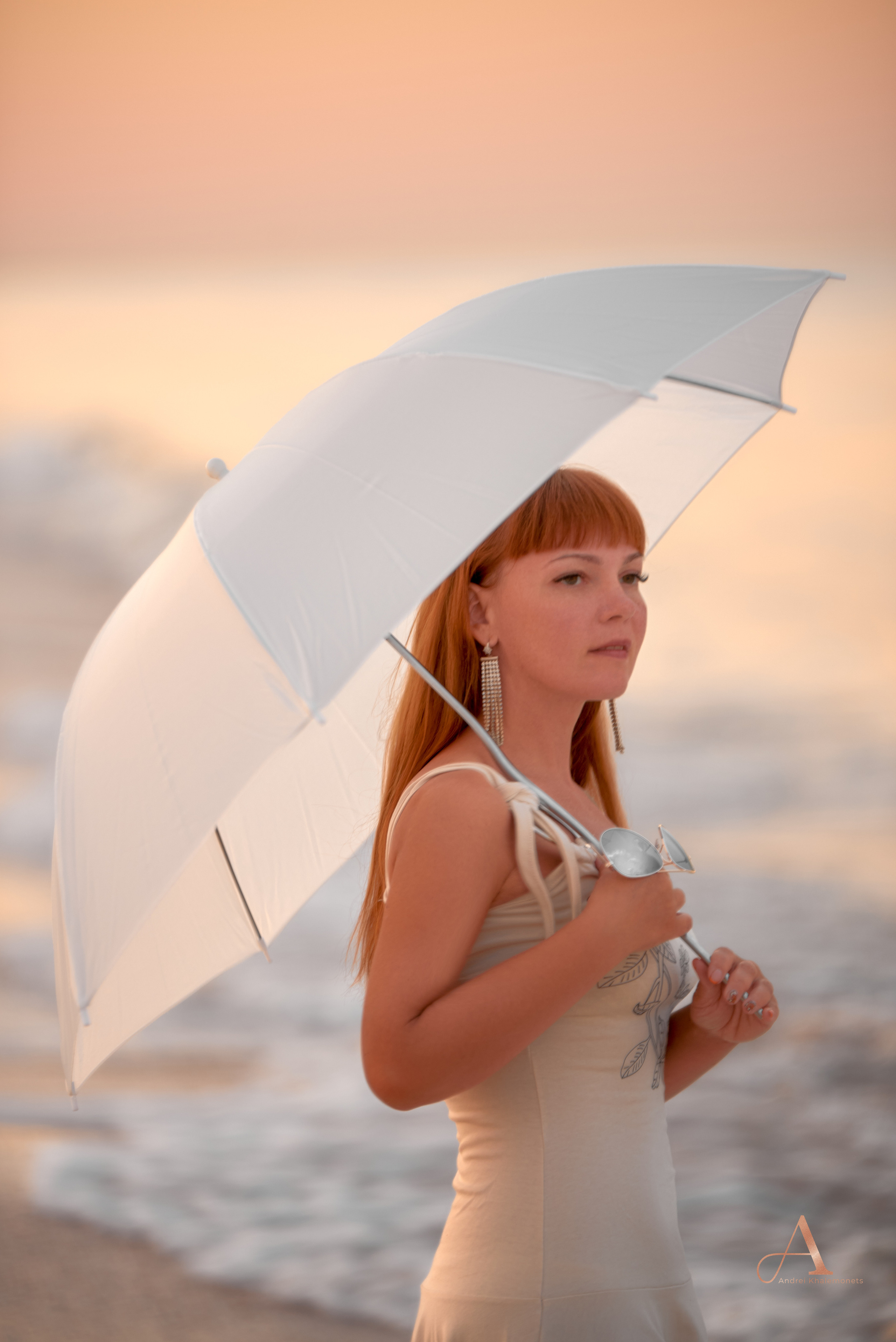 Девушка на берегу моря на рассвете, фотосессия с зонтиком.