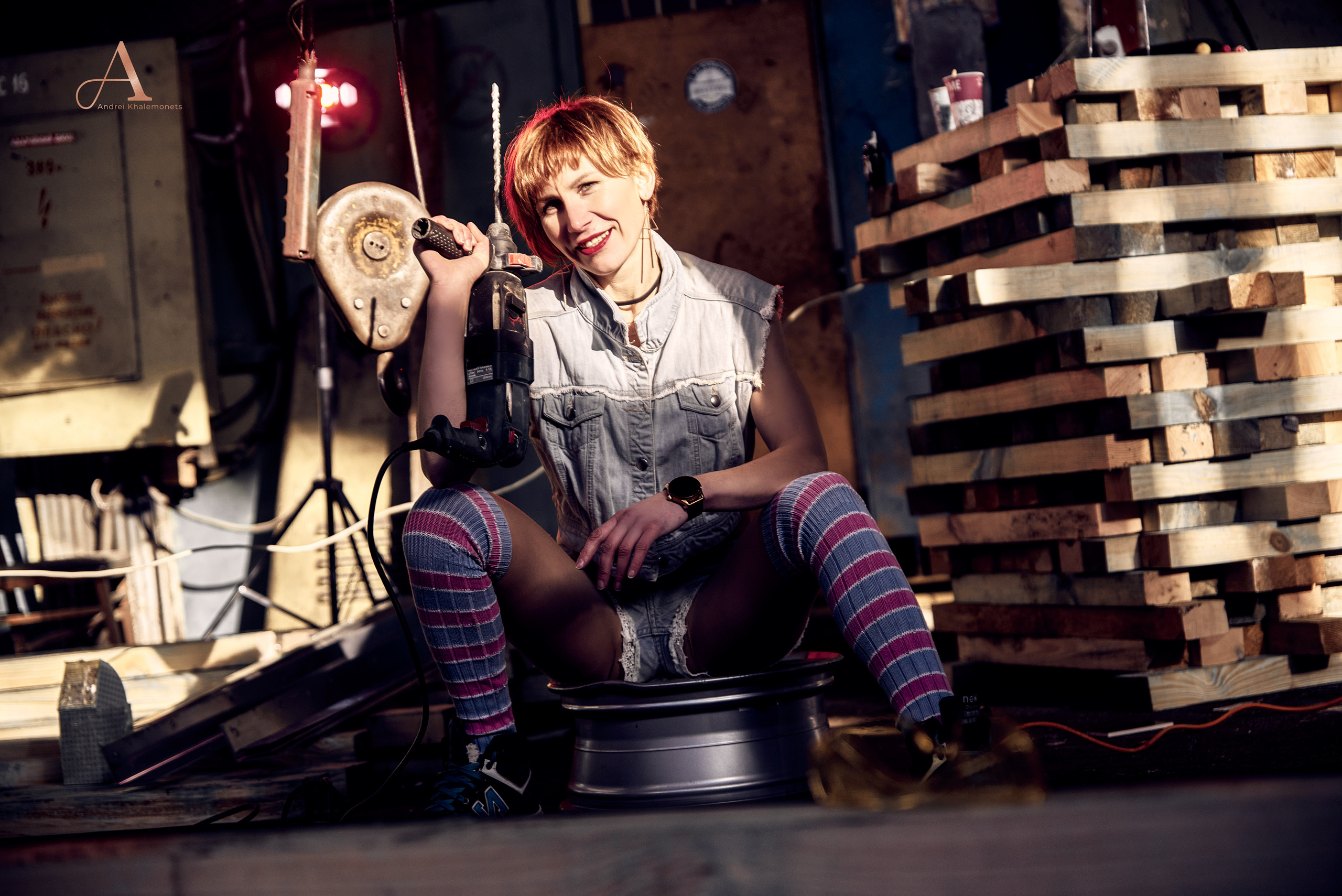 Девушка с перфоратором сидит на литом диске.