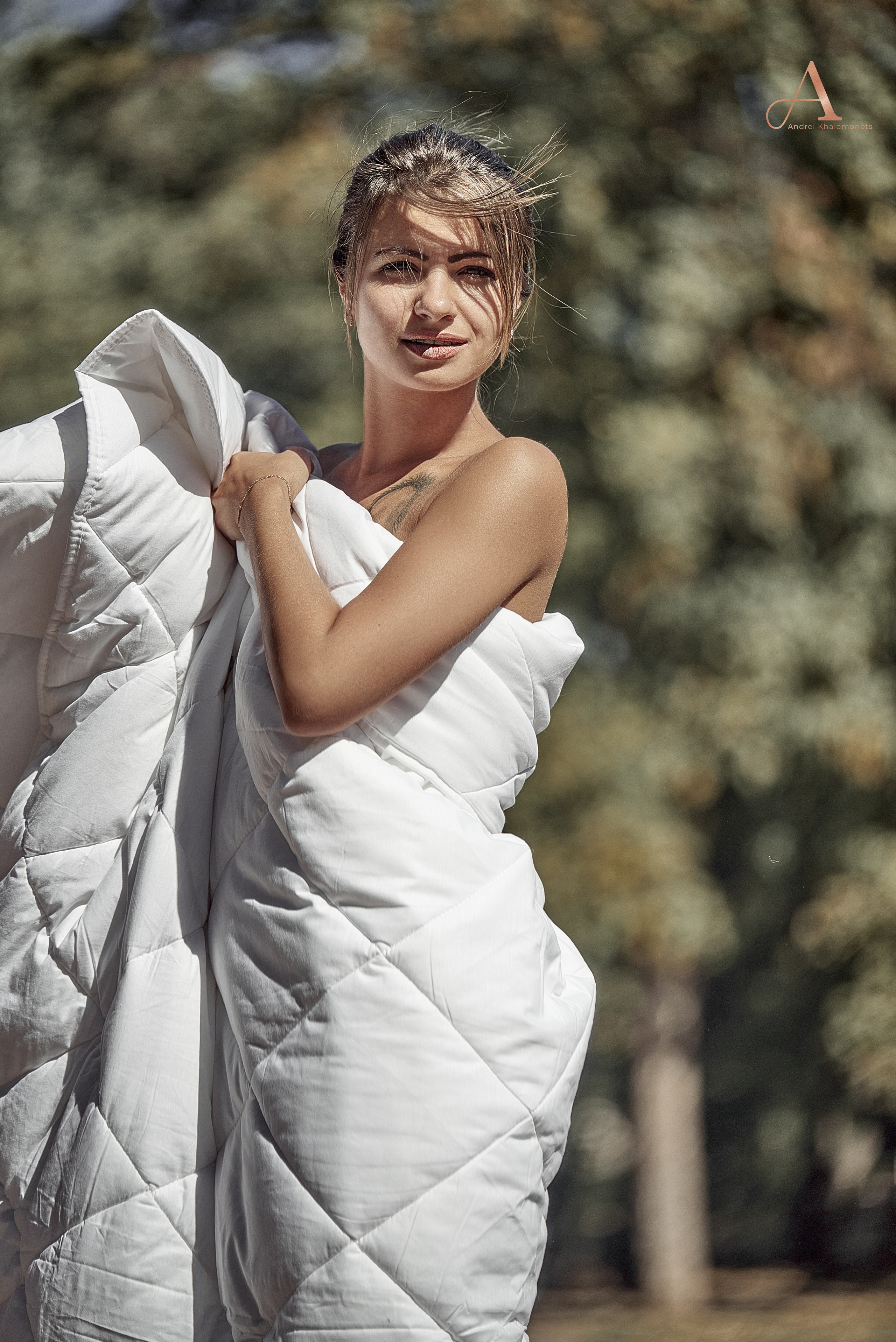 Обнаженная девушка за оборачивается одеялом в общественном месте.