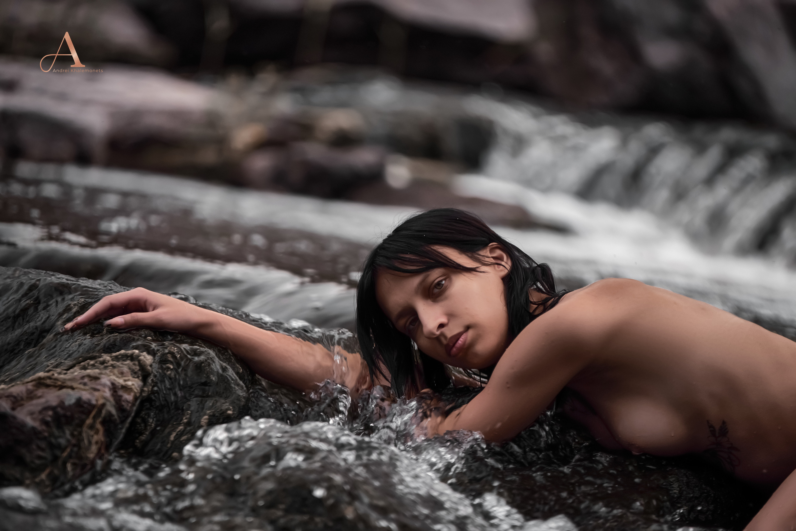 Обнаженная девушка позирует на камнях в воде, топовому ню фотографу в Кривой Рог Днепр Украина.