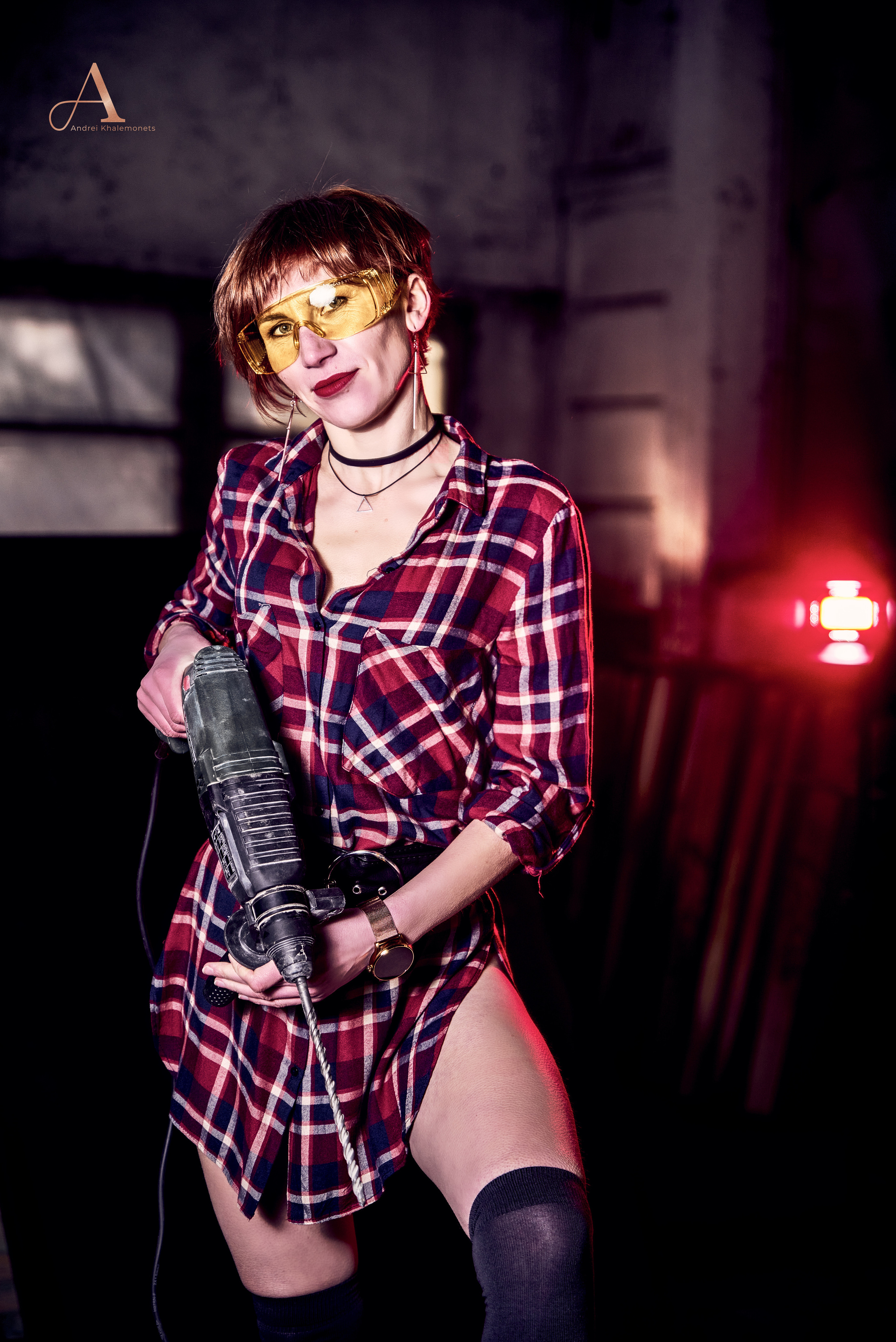 Девушка в красной клетчатой рубашке с перфоратором.
