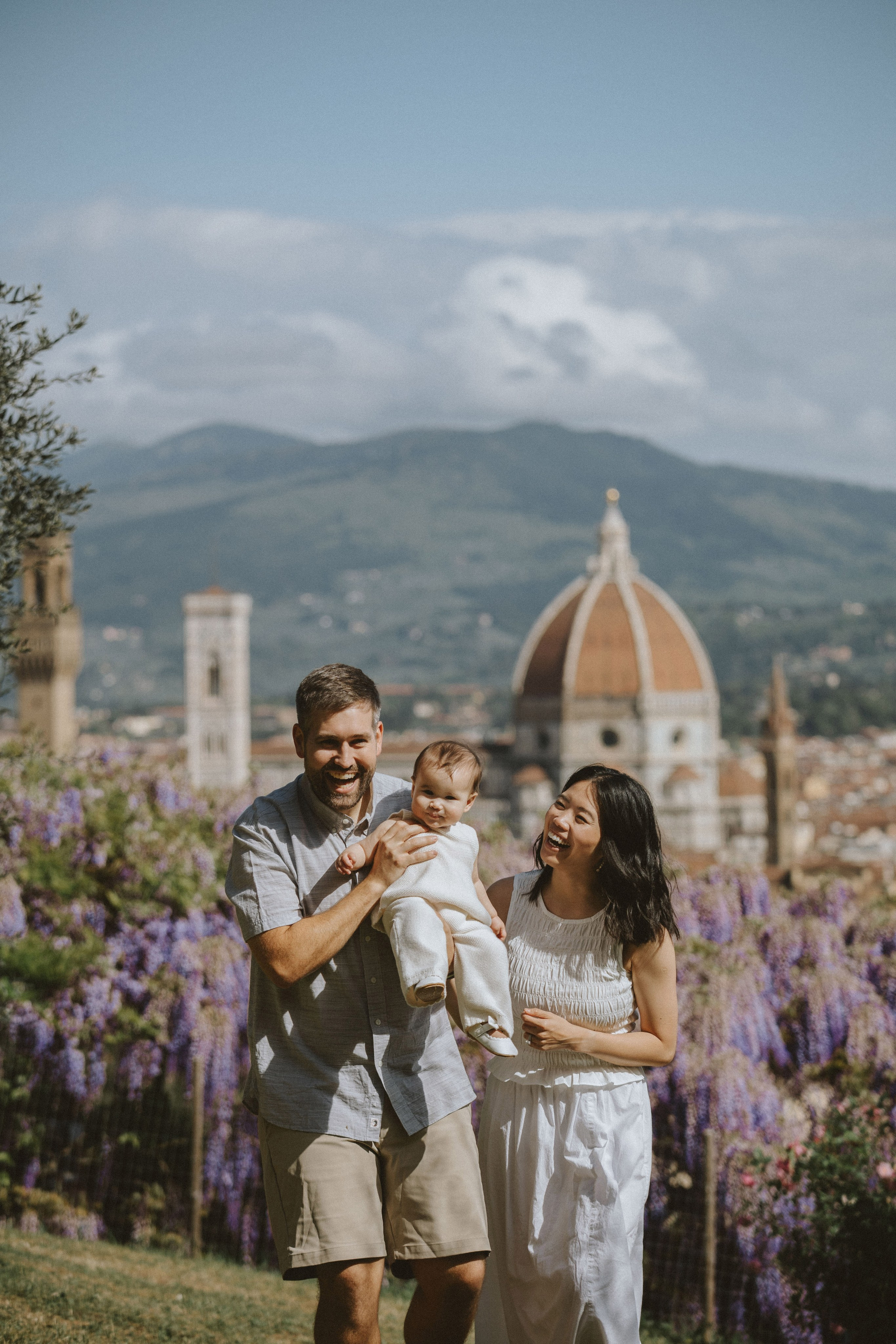 Famiglia che cammina attraverso i giardini di Villa Bardini con la cattedrale di Firenze in lontananza.