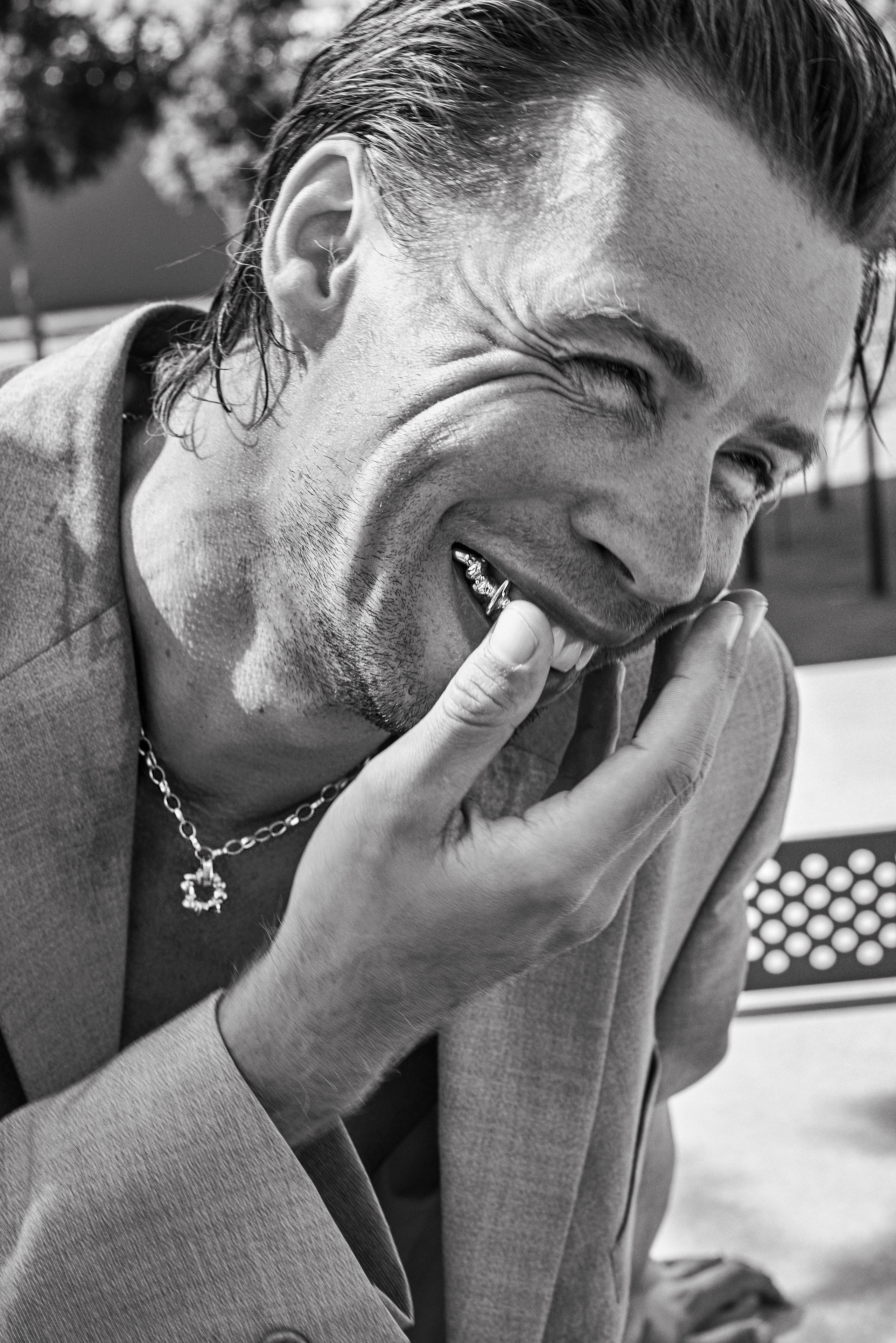 Black and white frame of a male model's arms with silver bracelets, European fashion campaign photography 