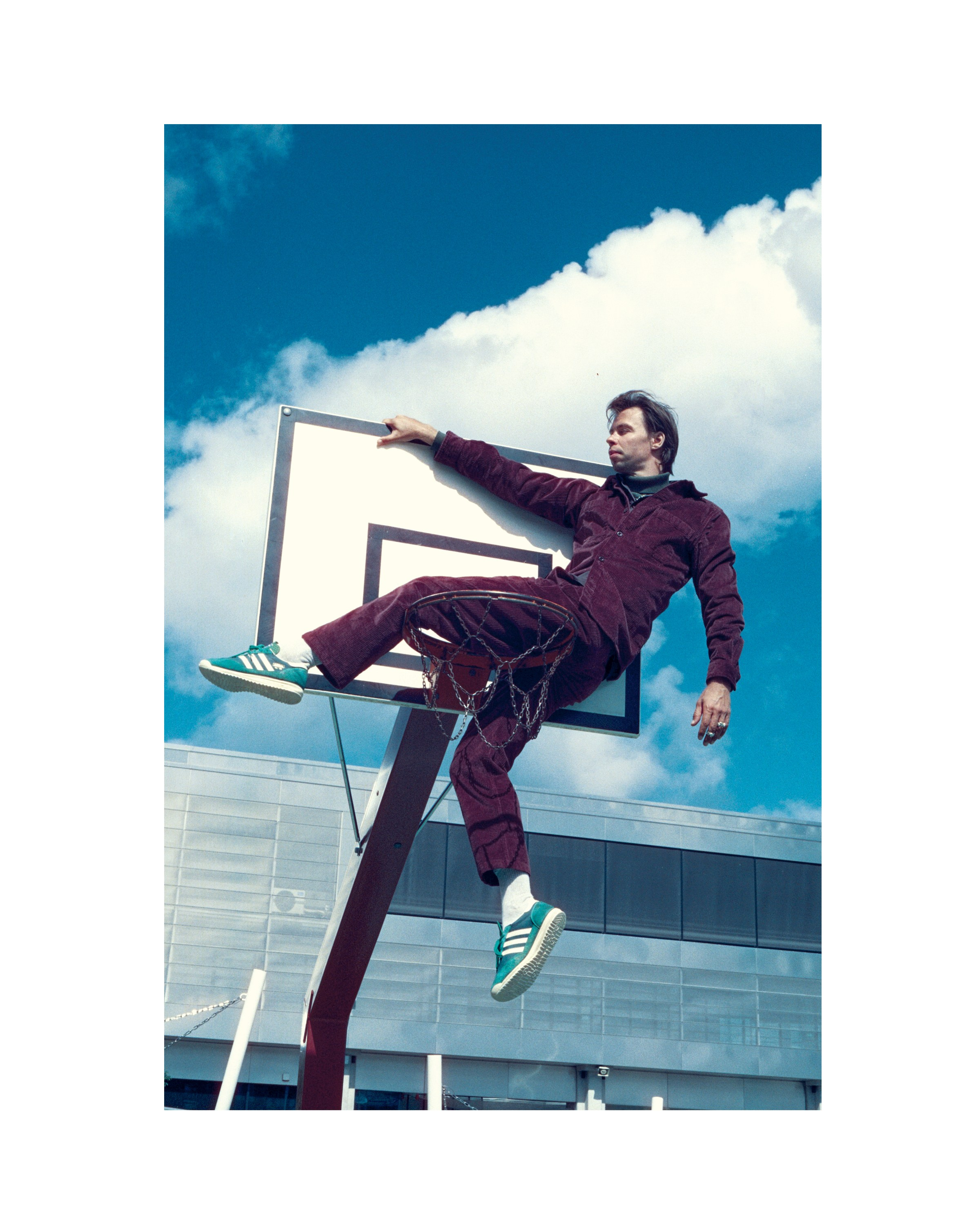 Male model in a dynamic sport pose wearing a silver chain necklace, streetwear jewellery campaign, Cinestill 800t