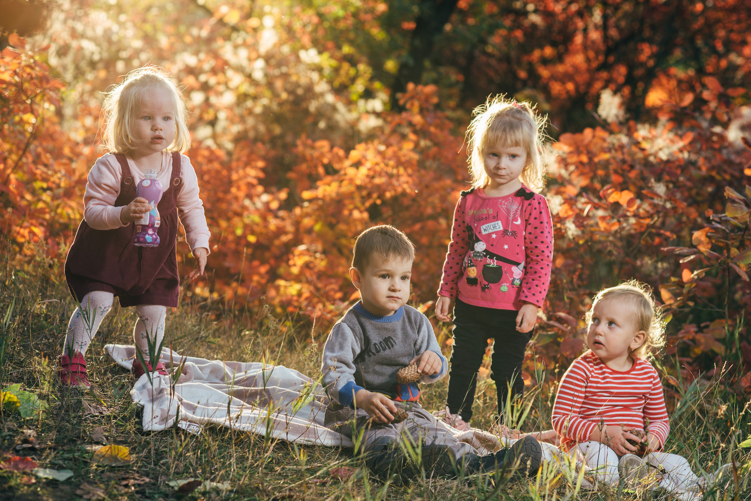 Фотография семьи в Днепре — родители обнимают детей среди деревьев.