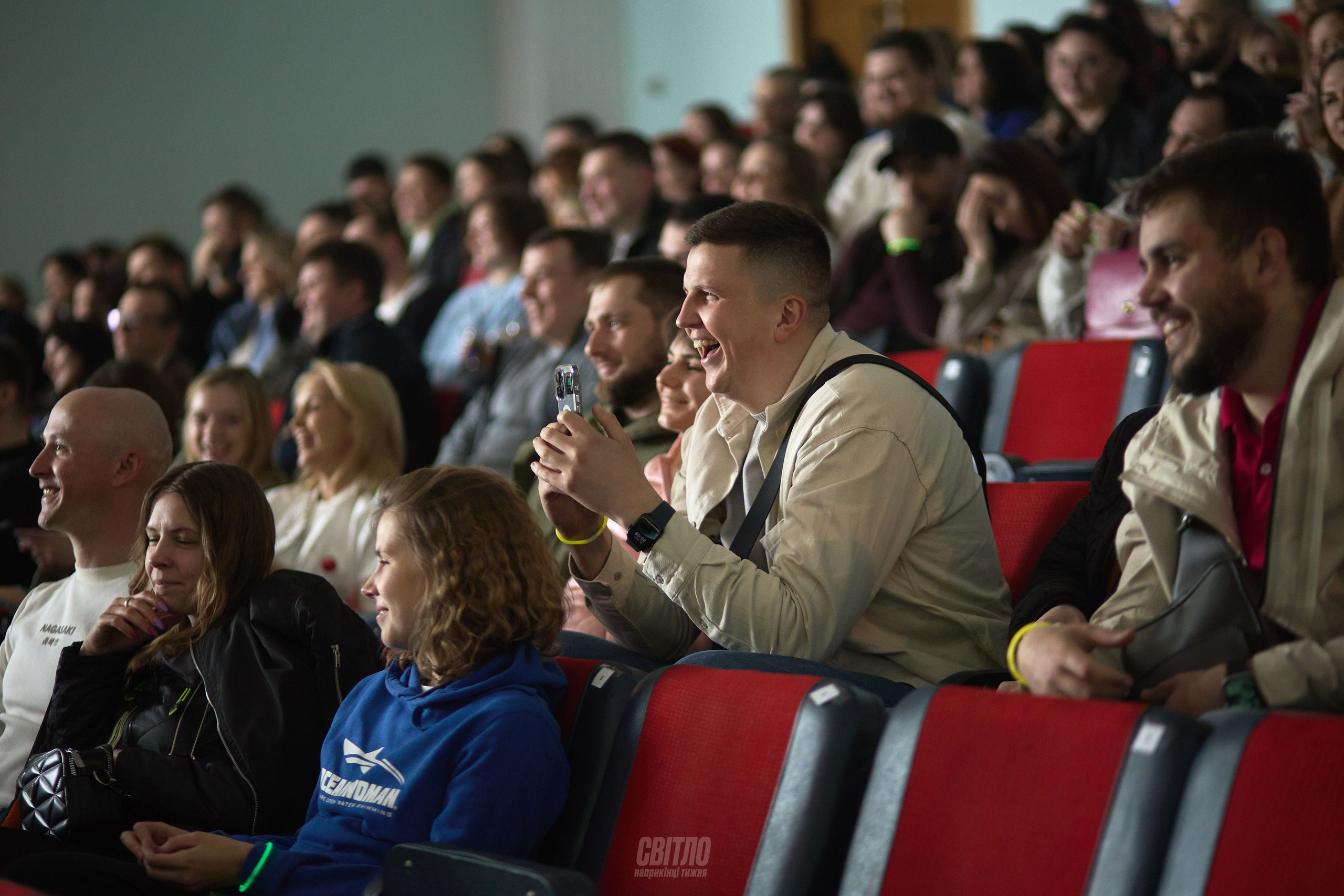 Фотограф у Дніпрі знімає репортаж заходу з емоціями гостей.