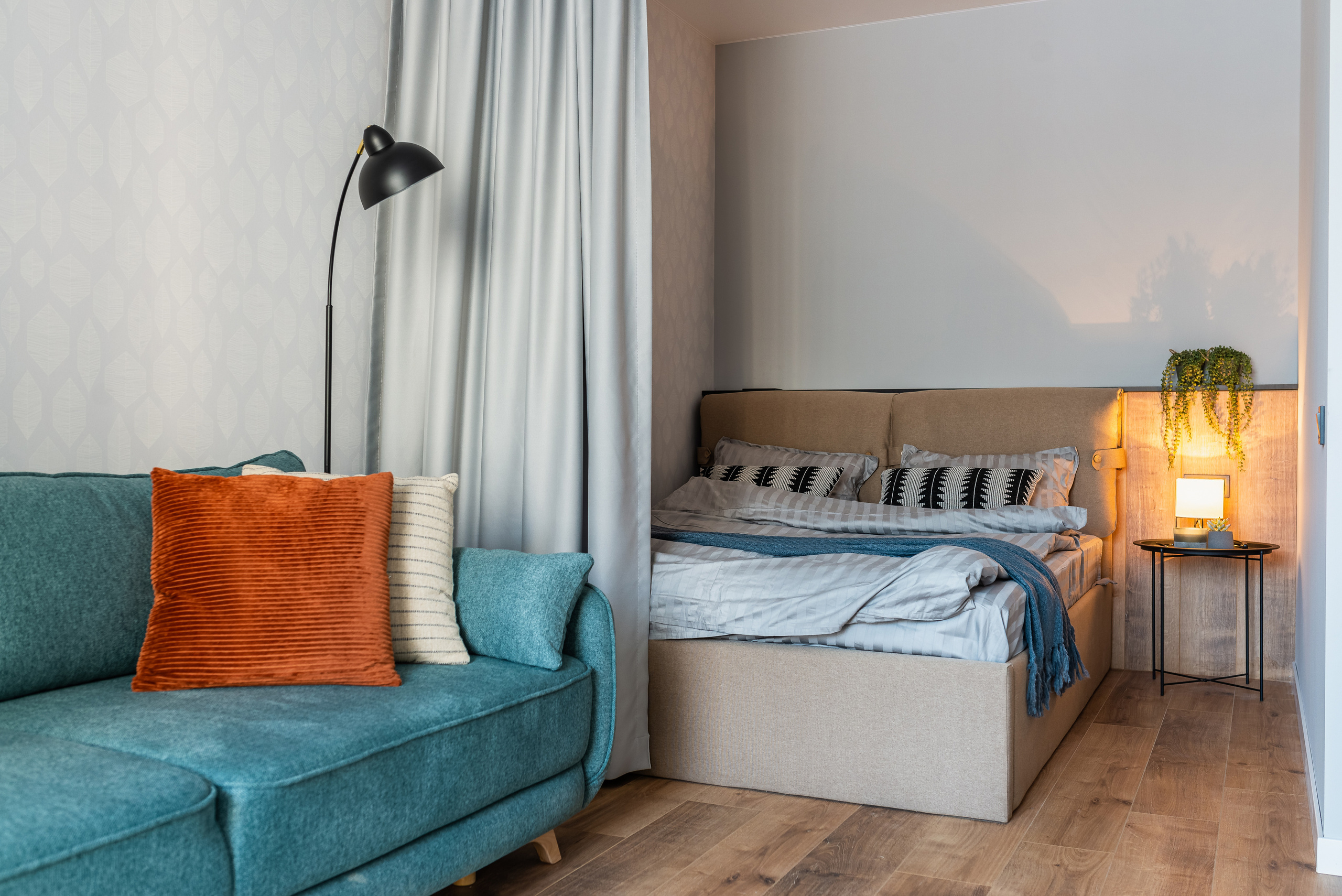 Интерьер спальни в Днепре с серой кроватью, деревянной отделкой и стильным освещением, создающим атмосферу уюта.