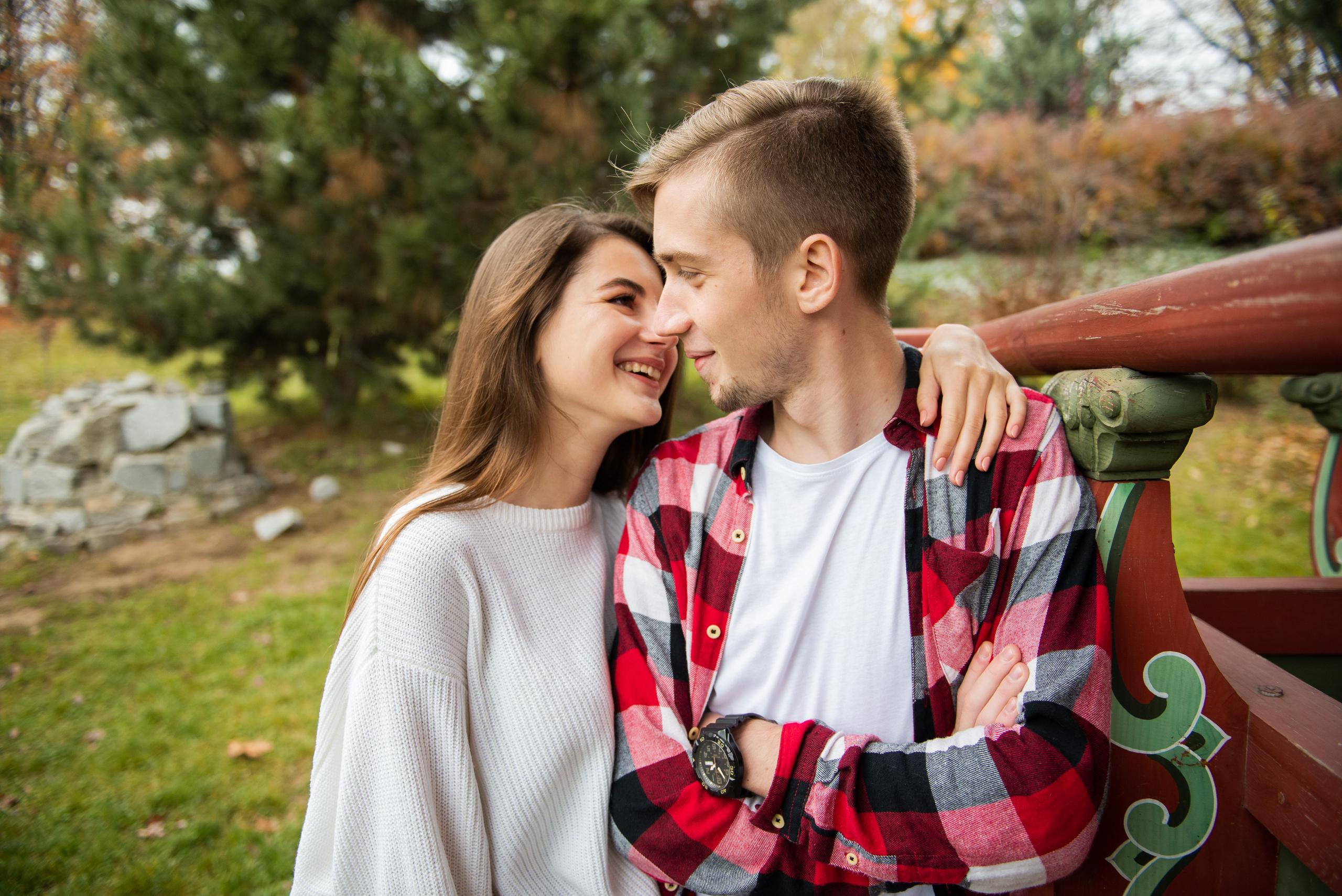Закохані сидять на лавці в парку, дивлячись на захід сонця