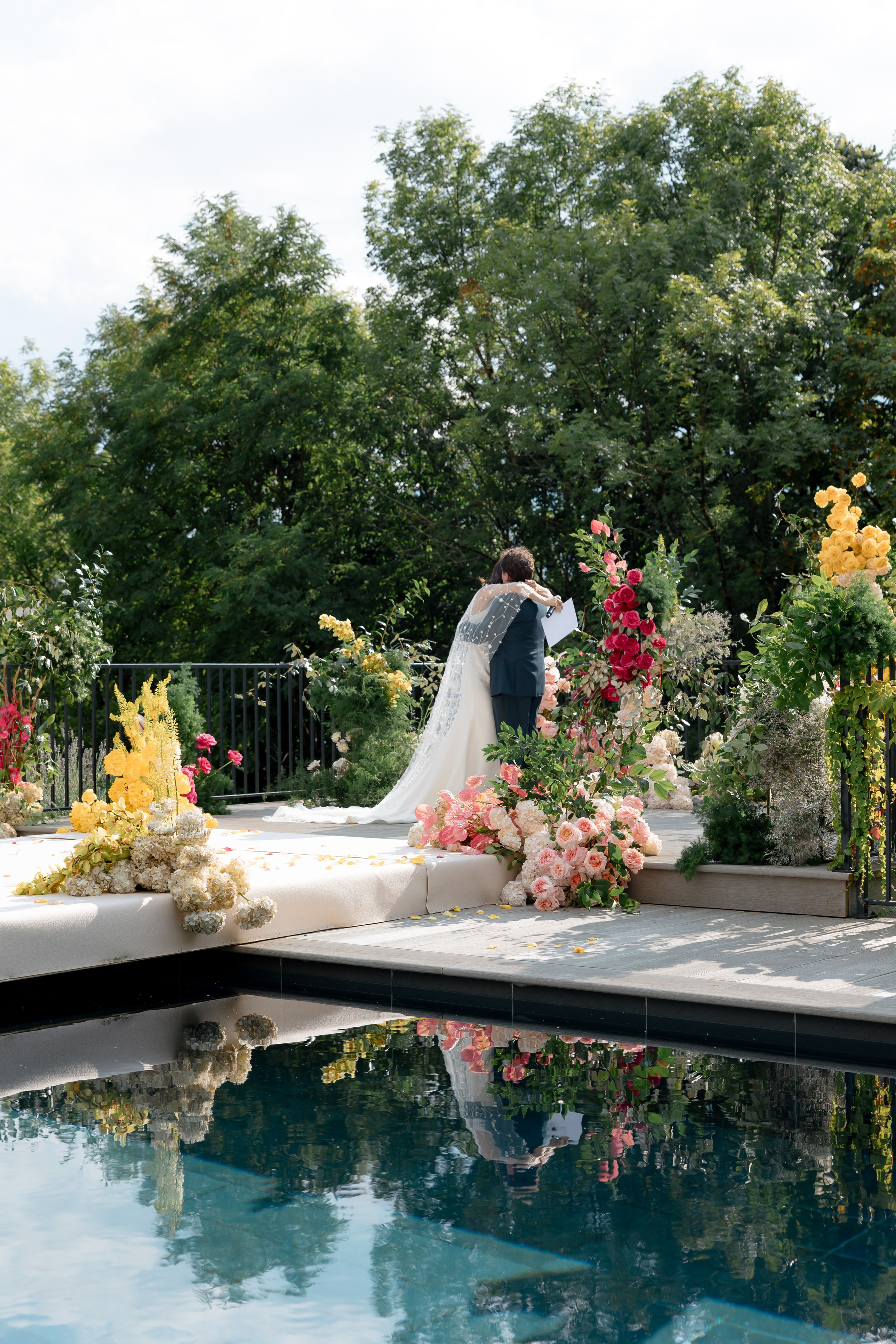 Editorial wedding portrait of bride and groom by pool at destination wedding