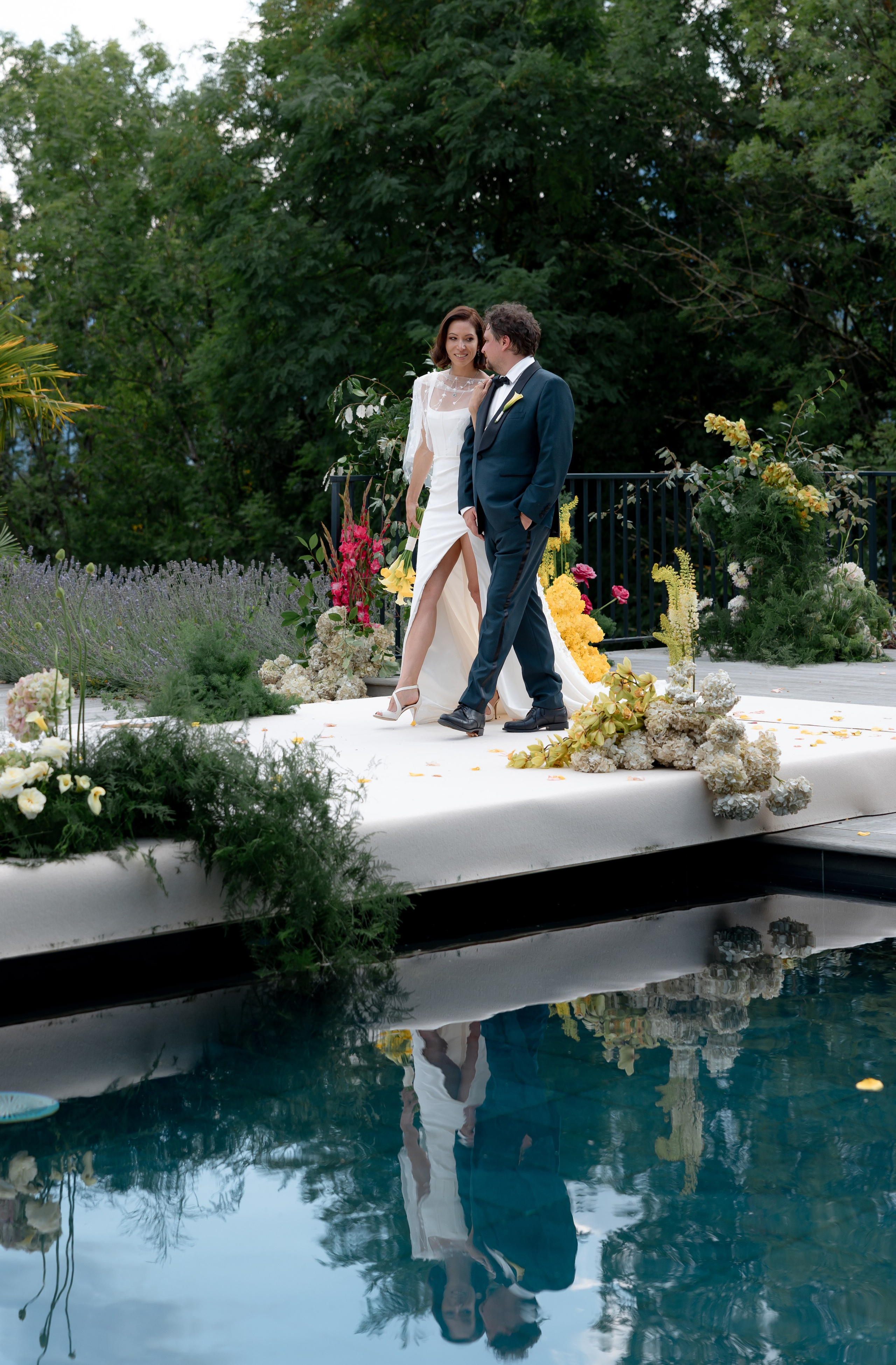 Editorial wedding portrait of bride and groom by pool at destination wedding