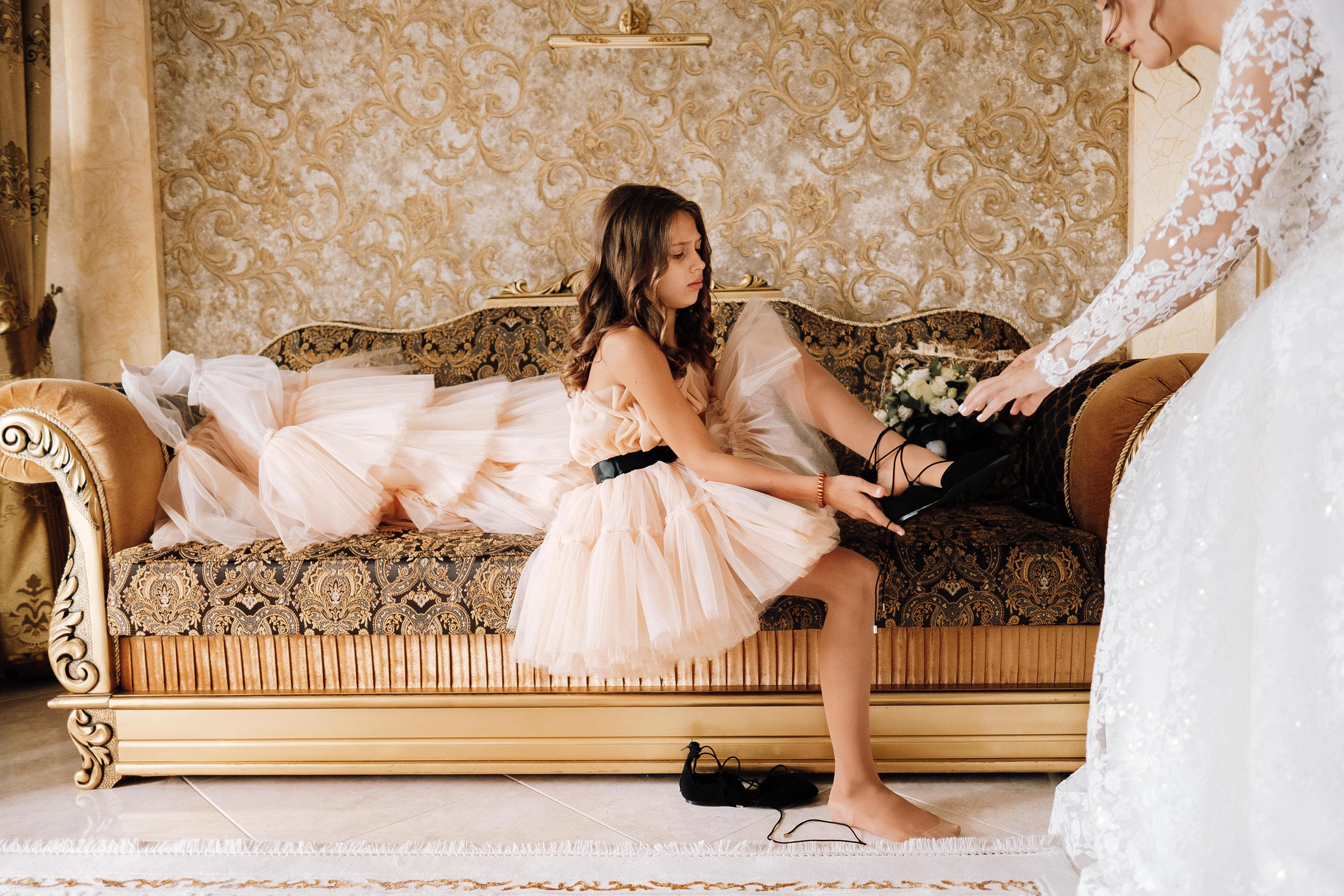 невеста помогает надеть туфли сестре