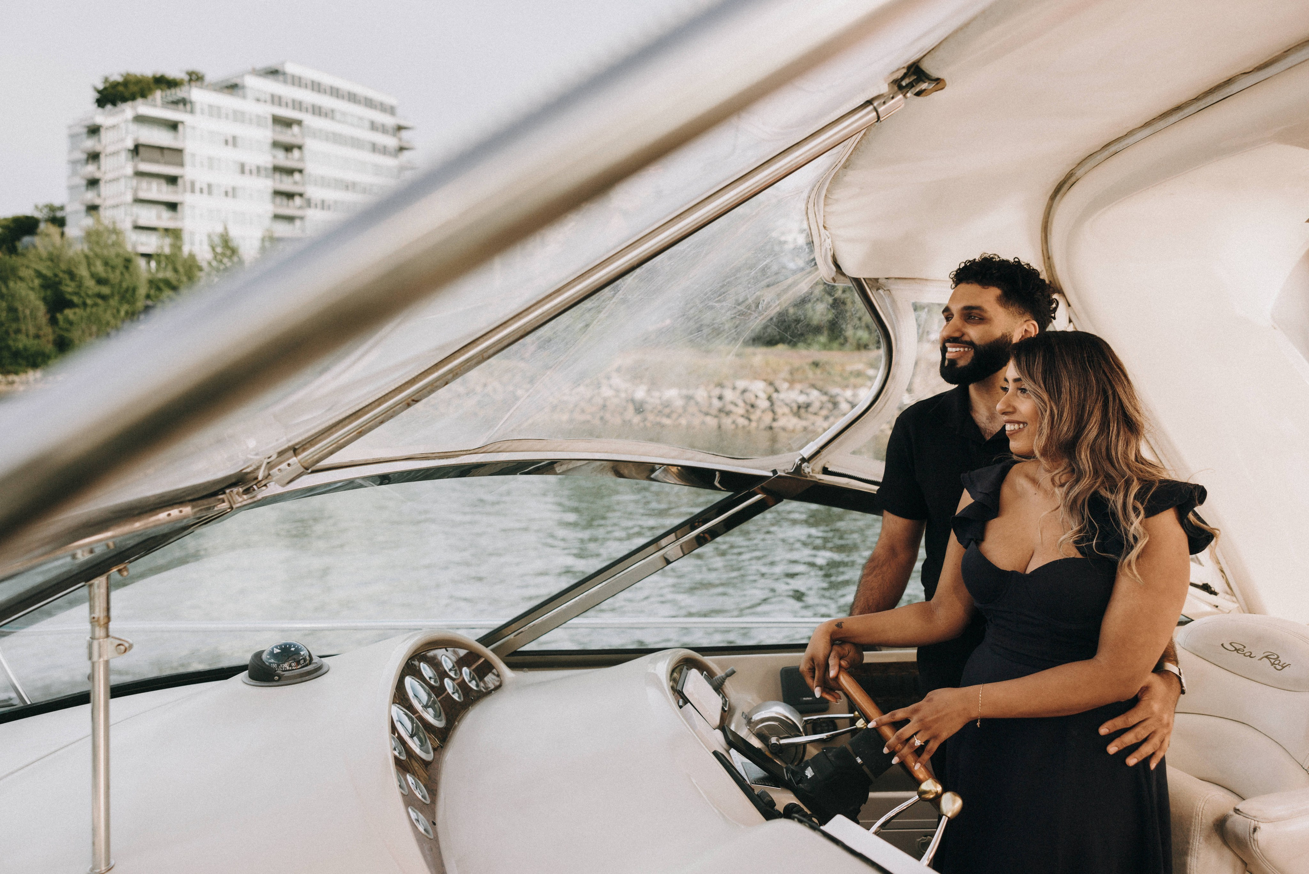     Happy couple celebrating their engagement on a private yacht in Vancouver, photographed at sunset.
