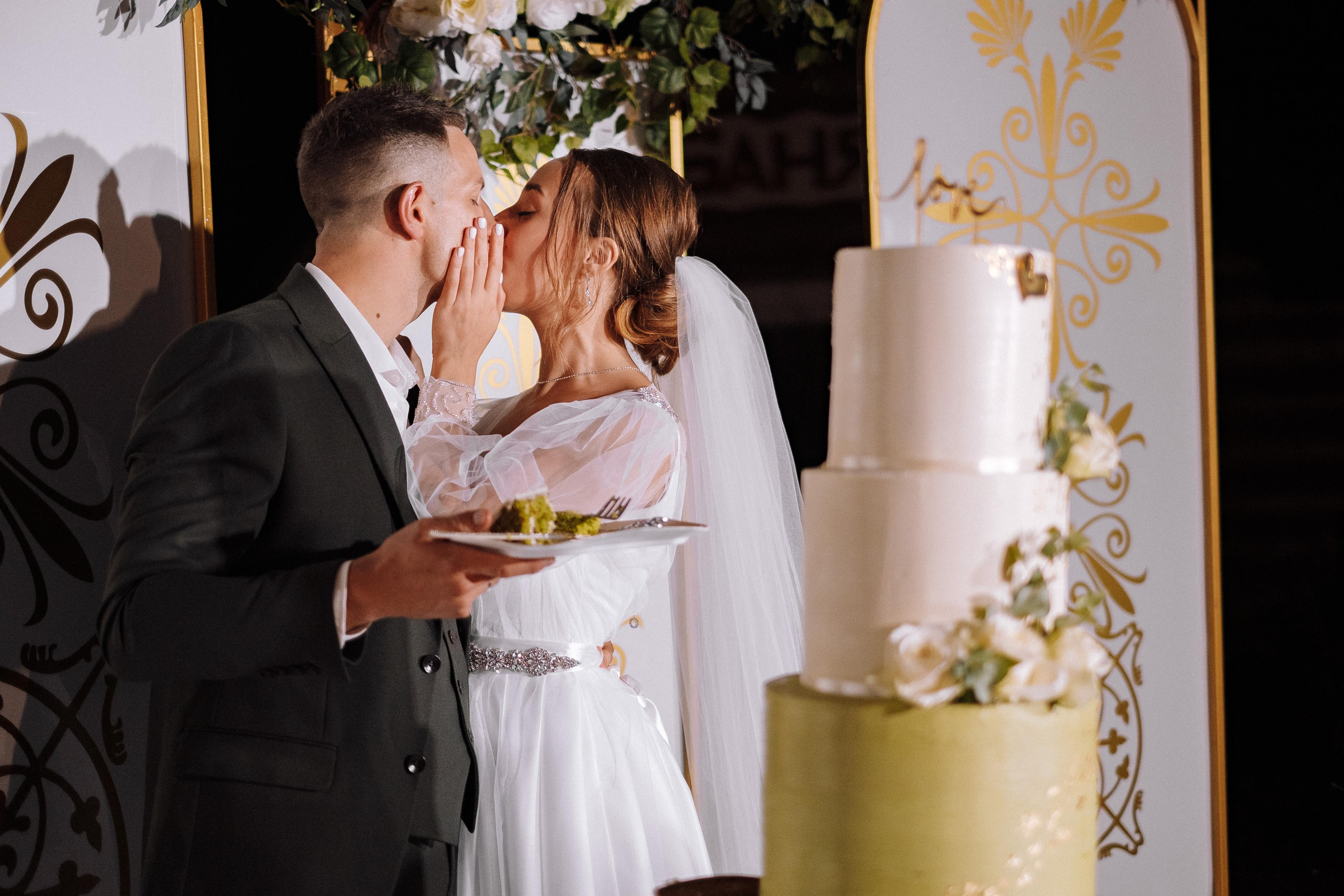 пара целуется на церемонии разрезания торта