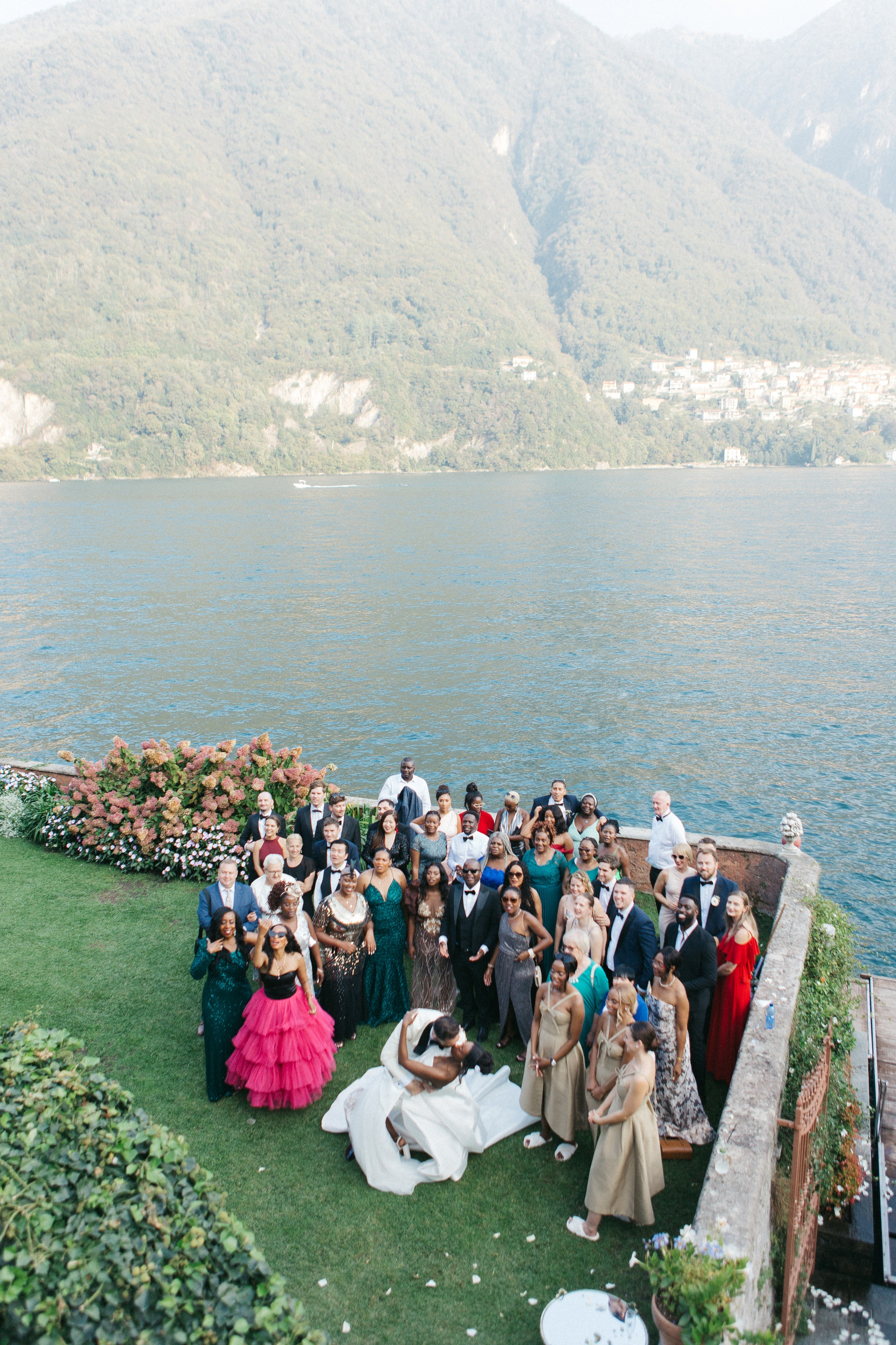 Joyful candid group photo of the bride, groom, and their wedding guests celebrating together
