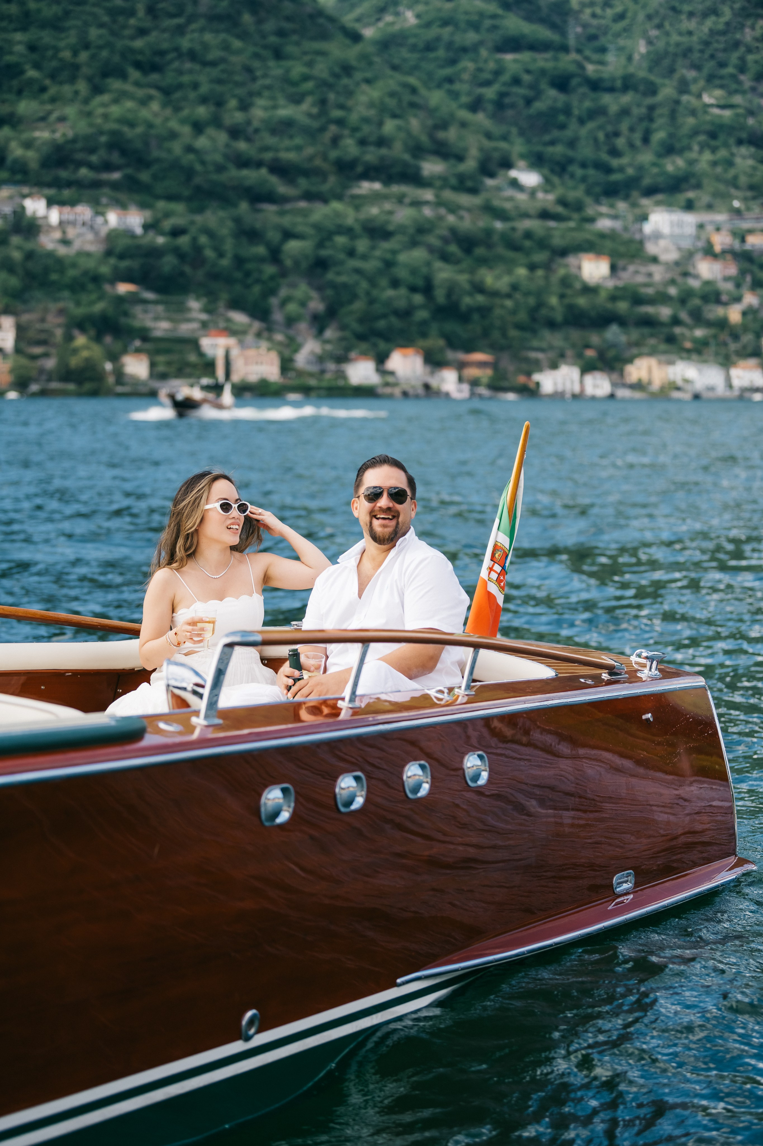 Couple in white sharing an elegant romantic boat celebration on Lake Como