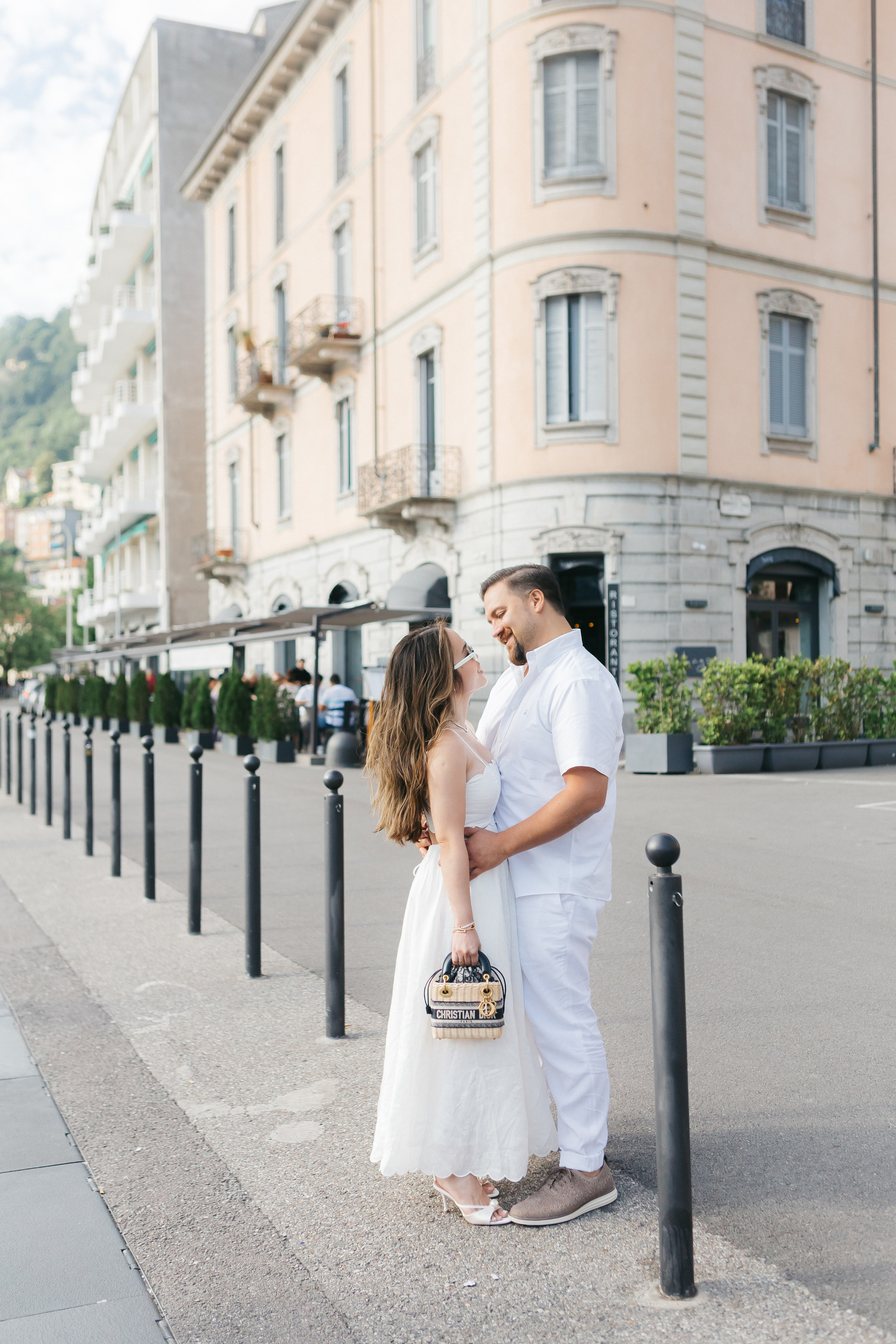 Fashionable bride highlighting her Dior bag as a wedding accessory in the shooting in Como lake 
