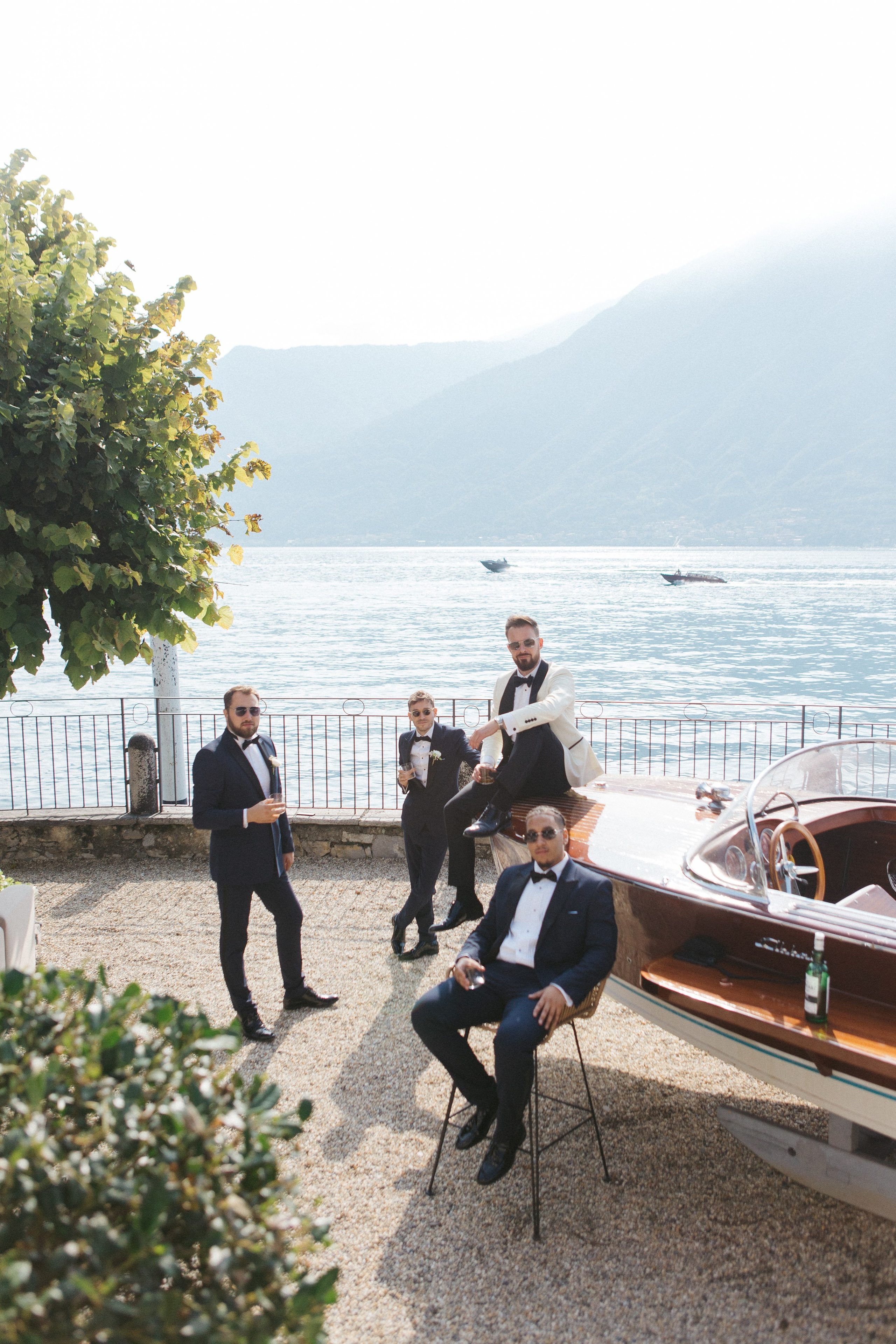 Como Lake wedding photographer captures groom and groomsmen posing with Lake Como behind them