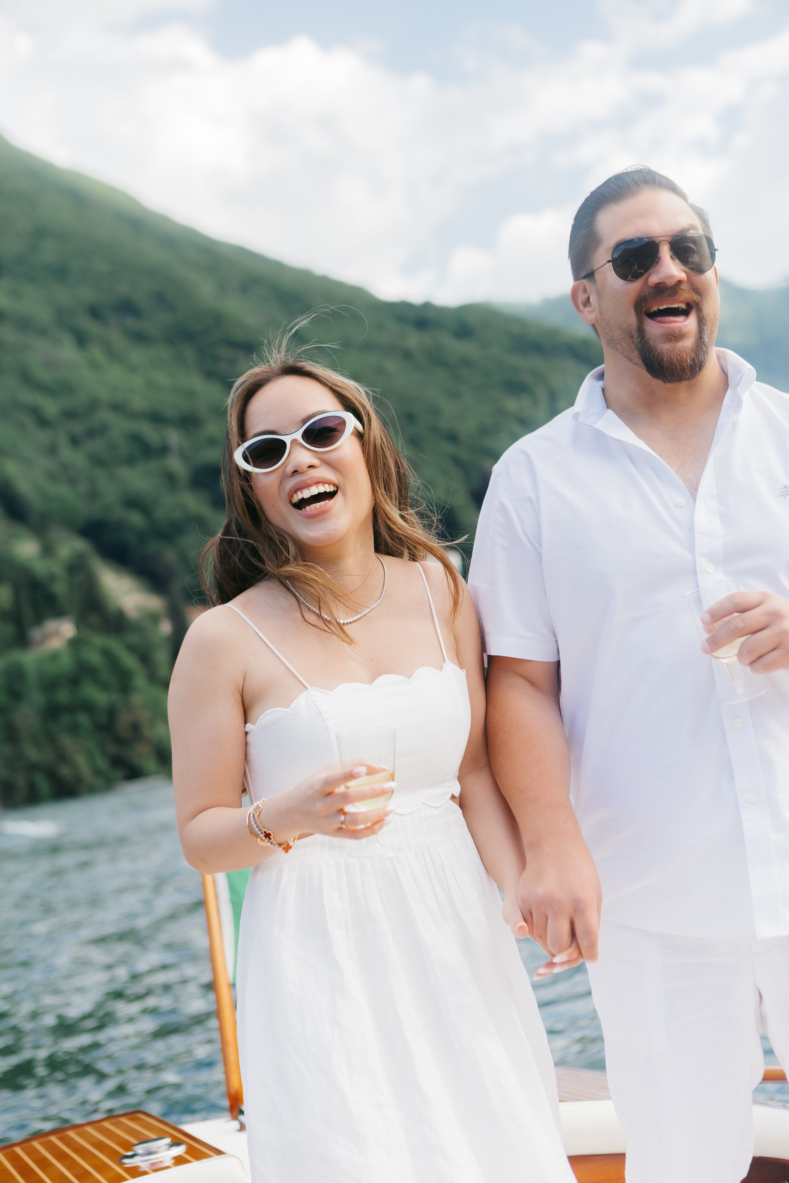 Couple in white enjoying a luxury pre-wedding romantic boat photoshoot on Lake Como