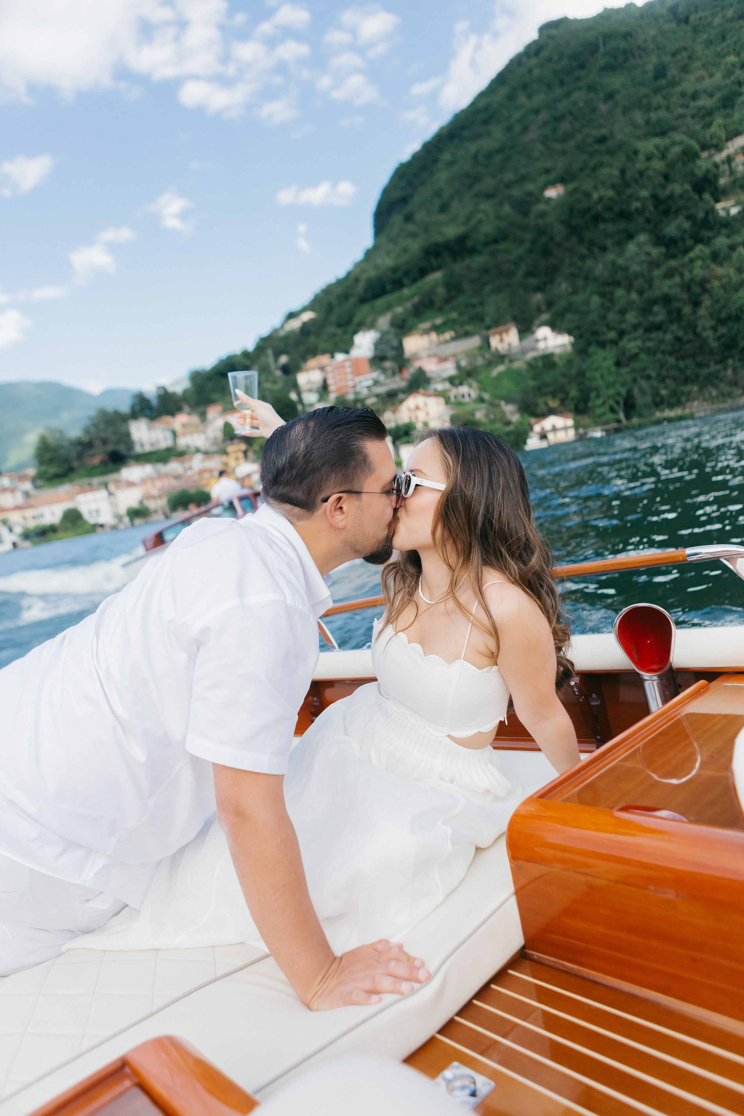 Couple in white enjoying romantic boat celebration and pre-wedding photography on Lake Como