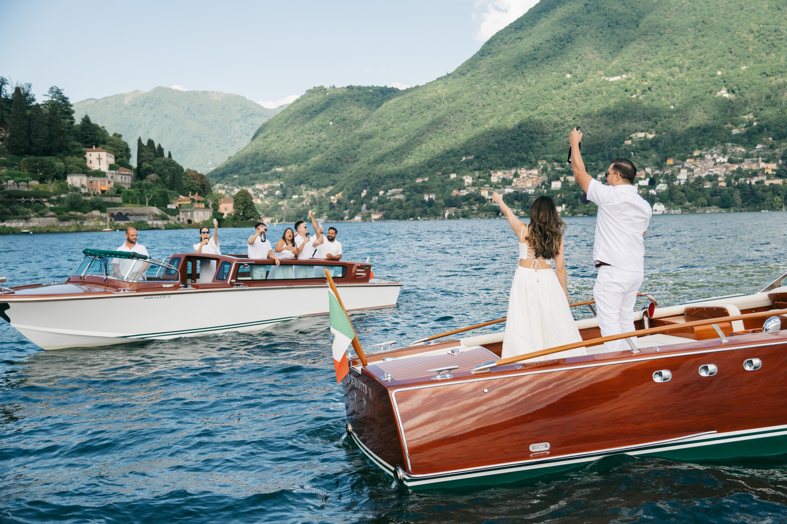 Stylish guests cheering the couple on a boat trip in Lake Como