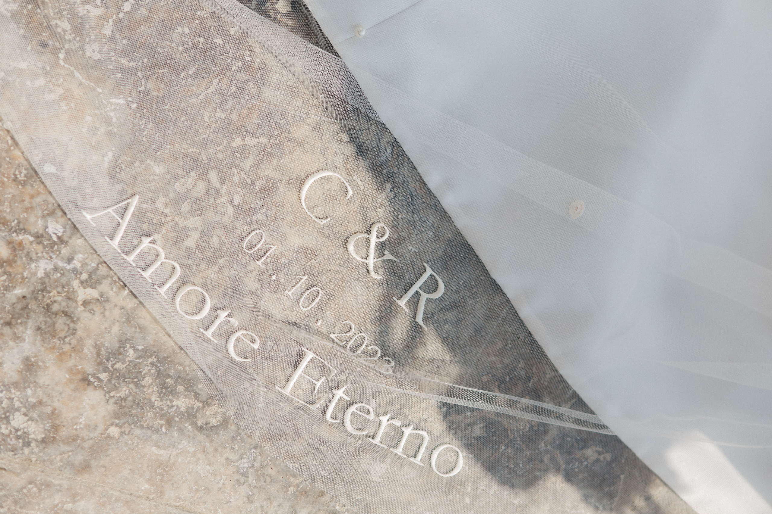 Luxury wedding detail: bride and groom’s monogram initials delicately embroidered on the veil