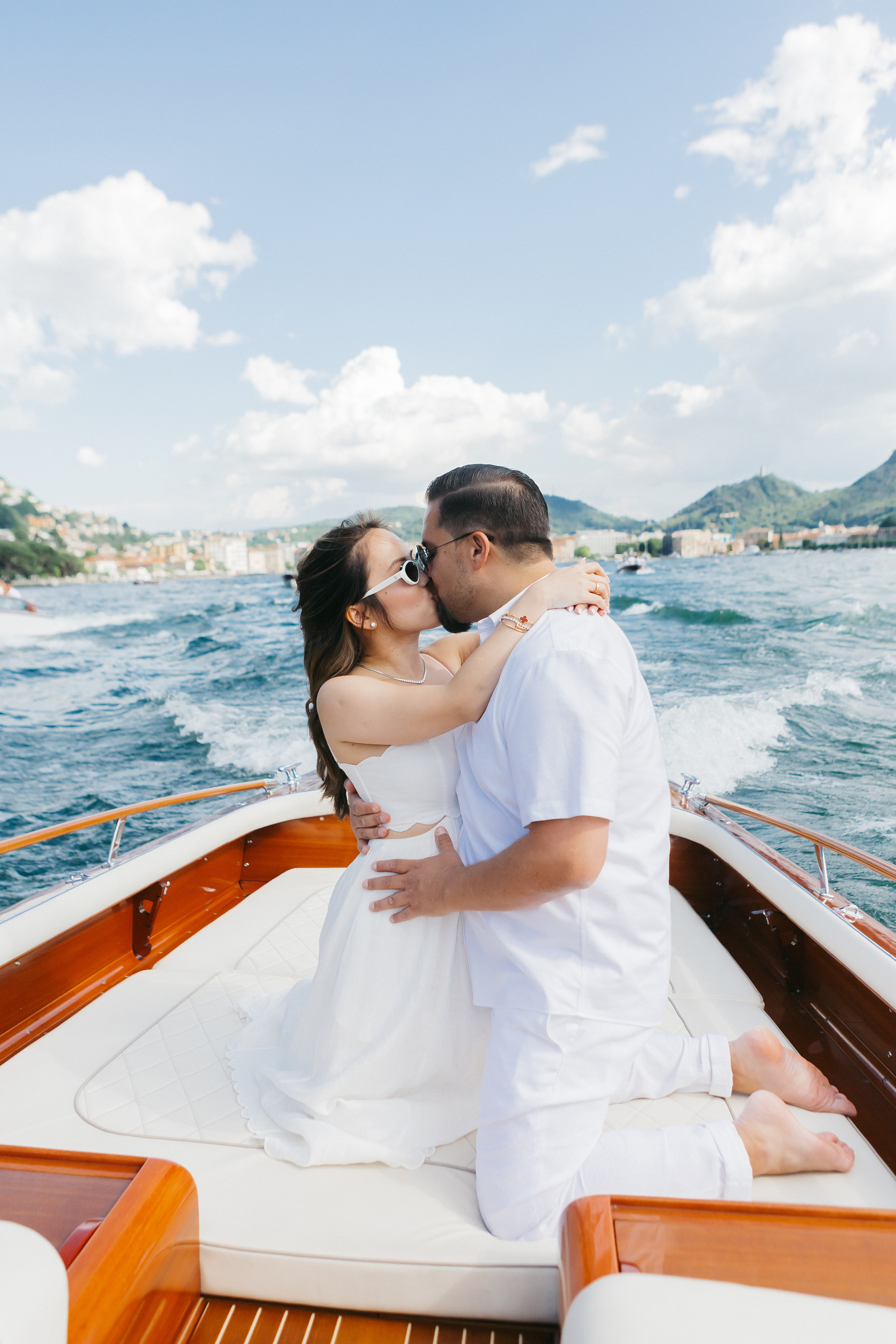 Couple kissing in a boat during their pre-wedding party on Lake Como