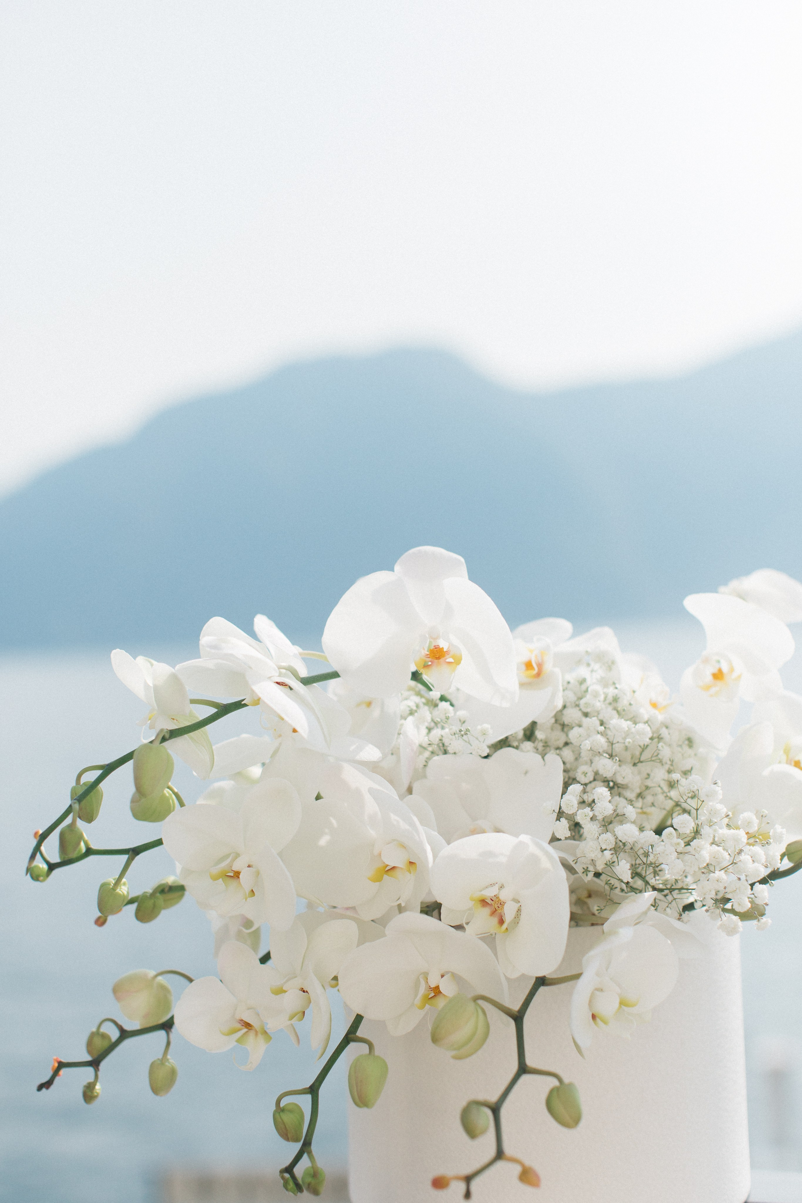 Wedding bouquet with white orchids against the backdrop of Lake Como