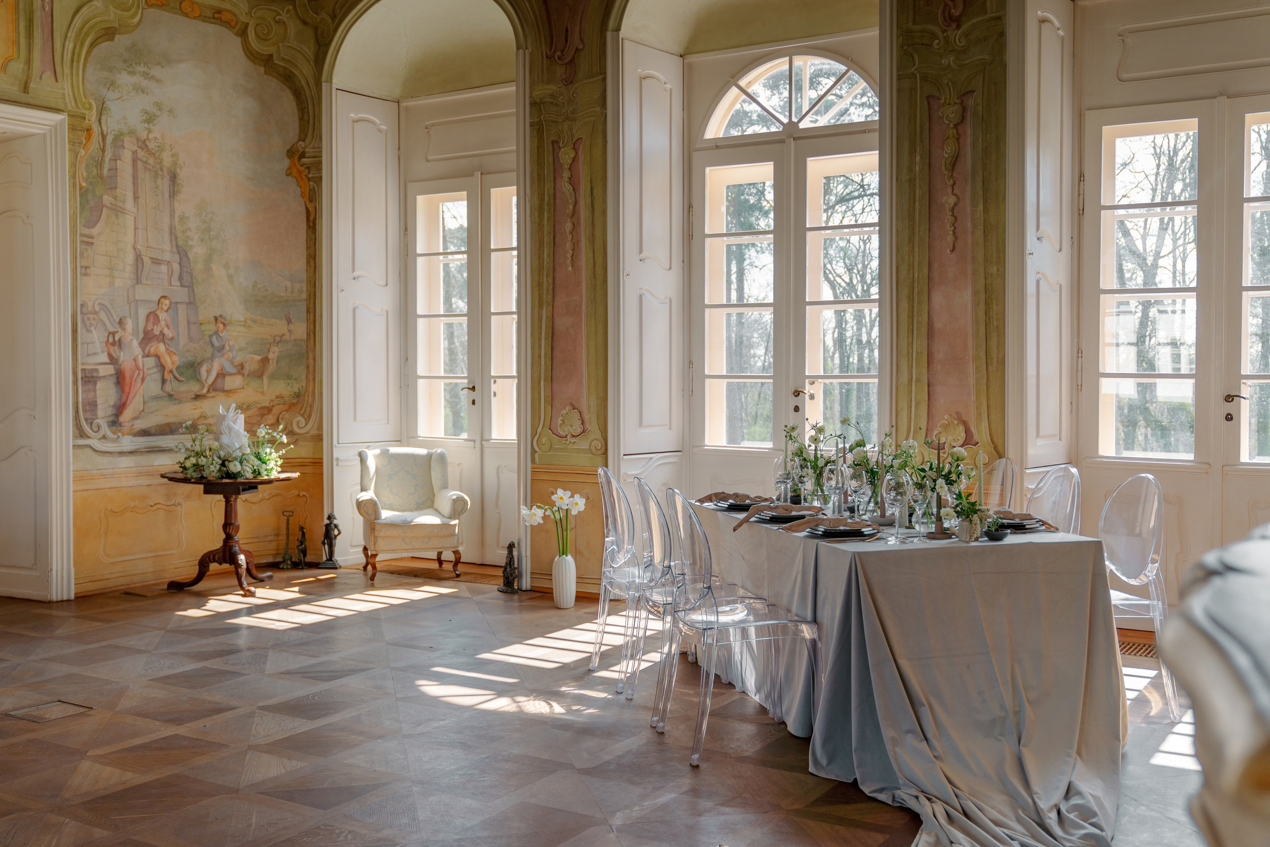 Комната в которой свадебные декорации, стол, торт посуда и цветы в вазе в дали