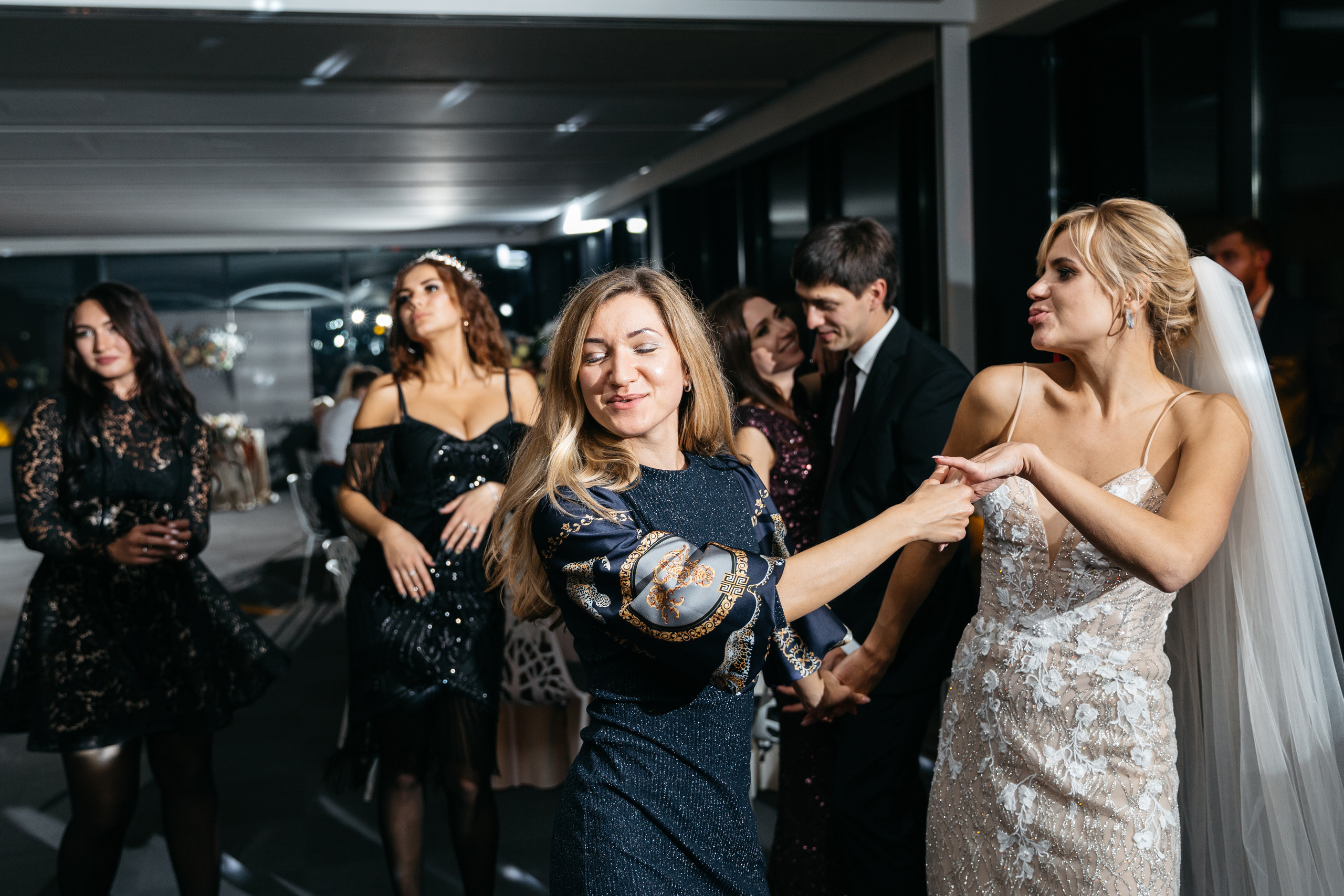 невеста танцует с гостями на банкете в ресторане