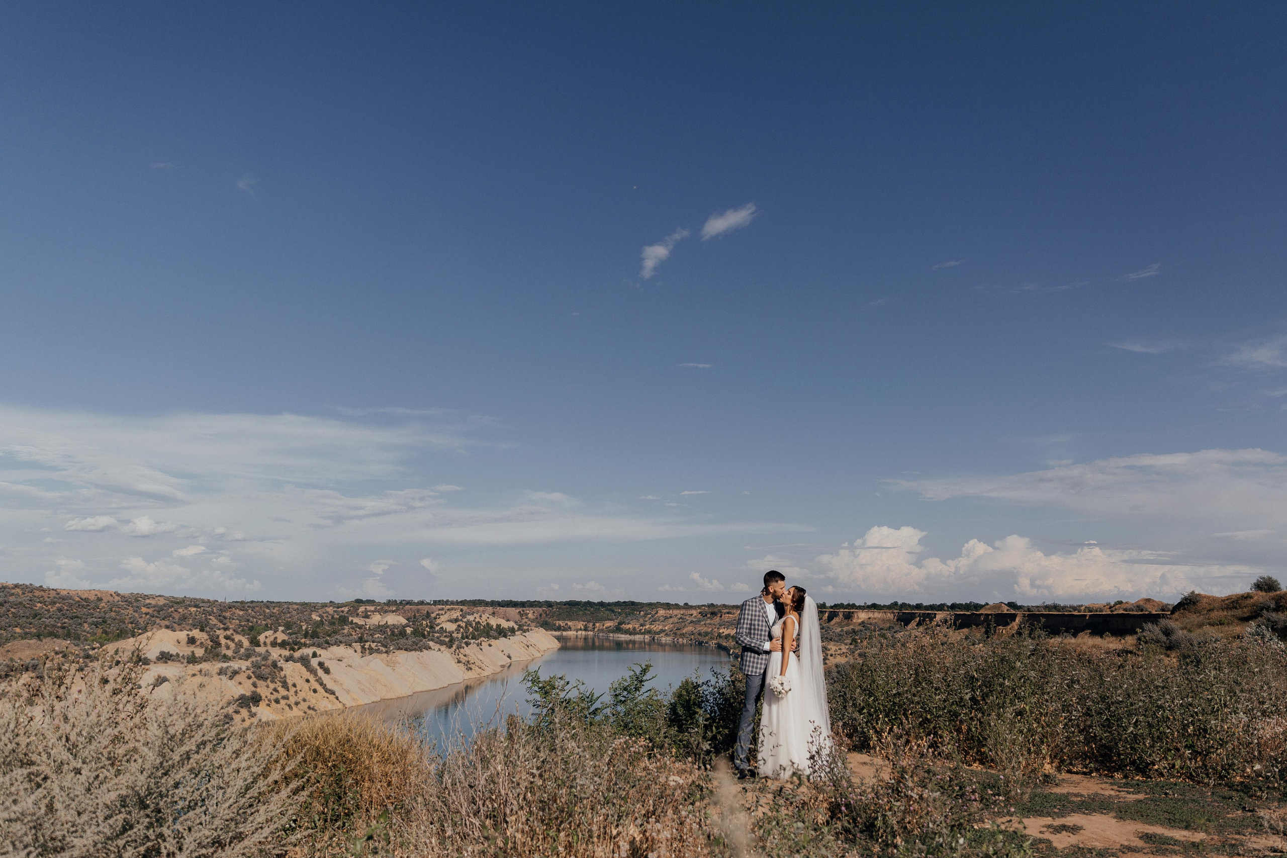 Пара обнимается на свадебной прогулке на фоне Александровского карьера 