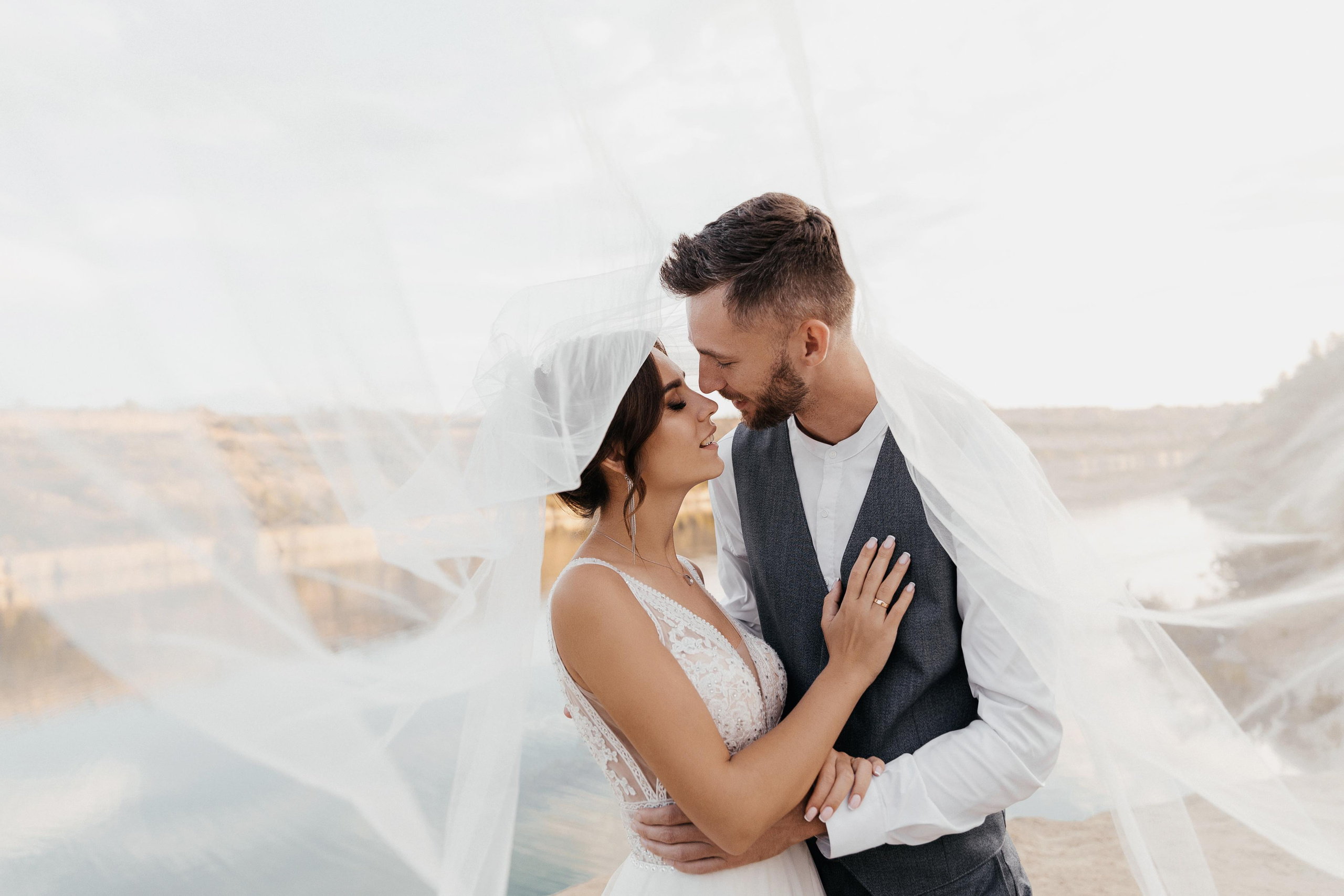 жених целует невесту в фате