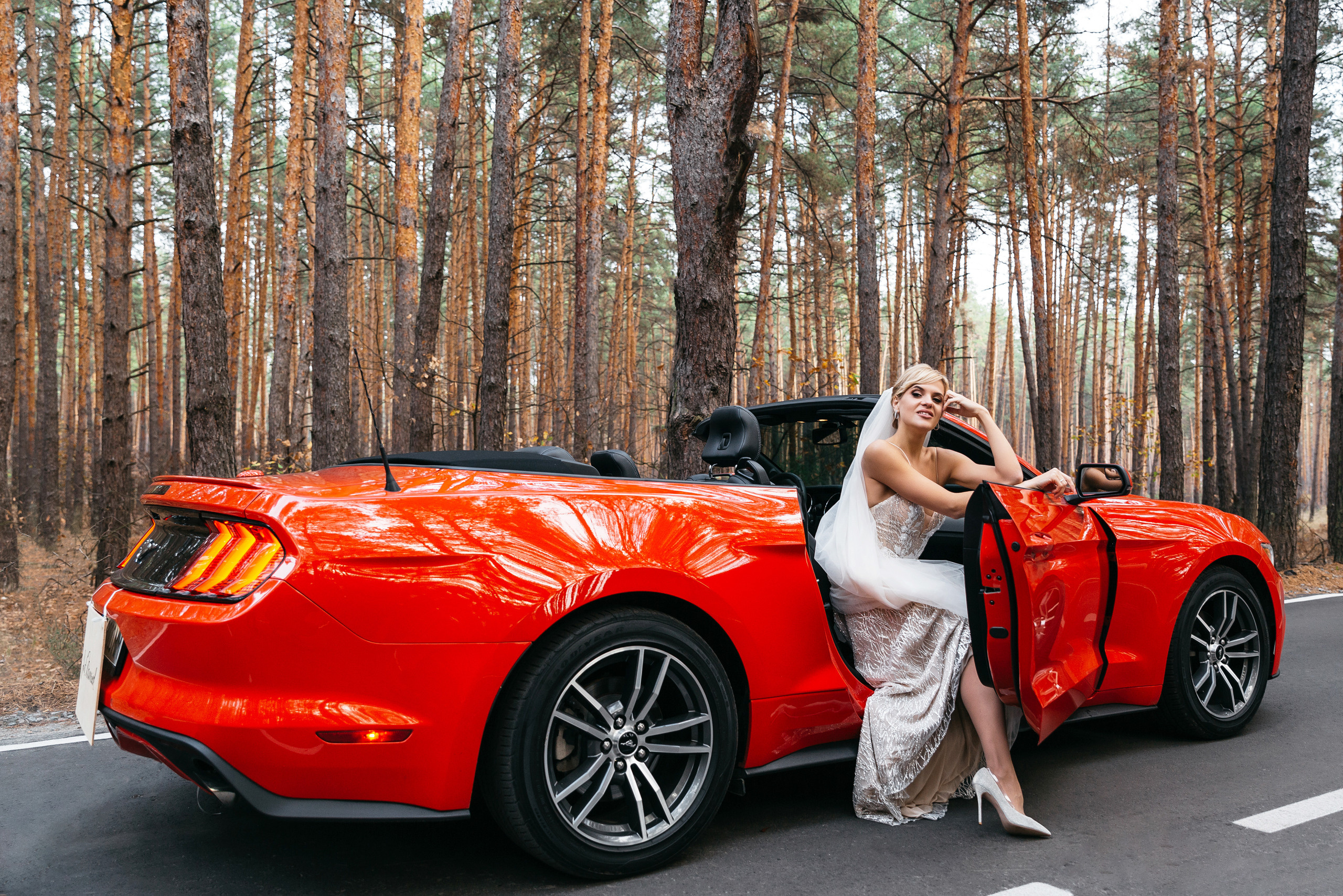 невеста сидит в красном кабриолете