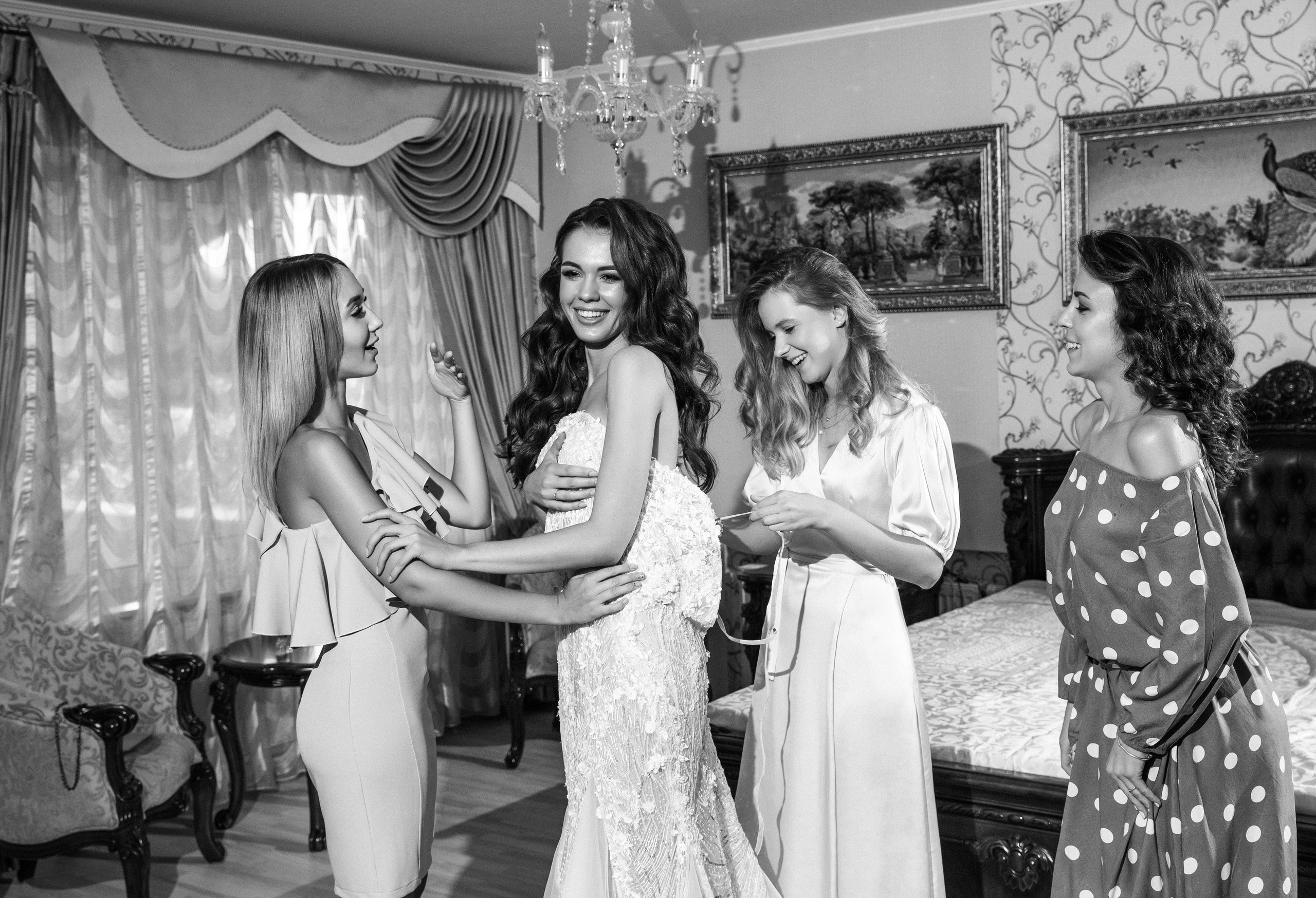 подружки невесты радуются вместе с невестой смеются и шнуруют платье Кременчуг