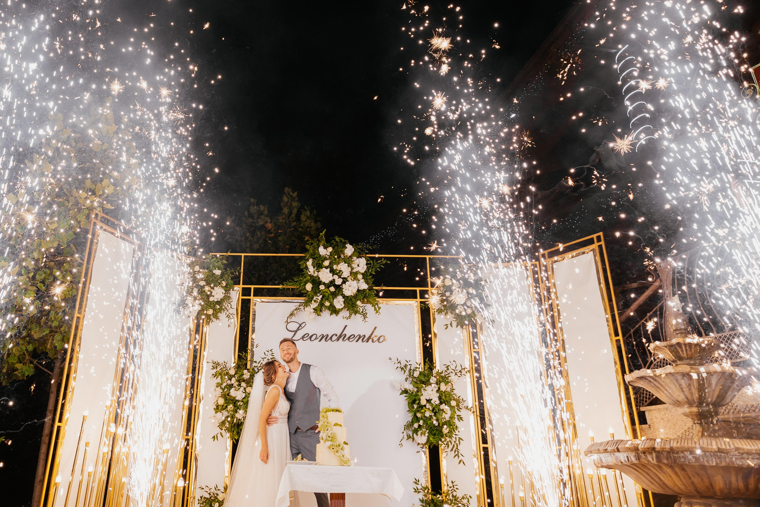 разрезания торта жених и невеста радуются холодные фонтаны