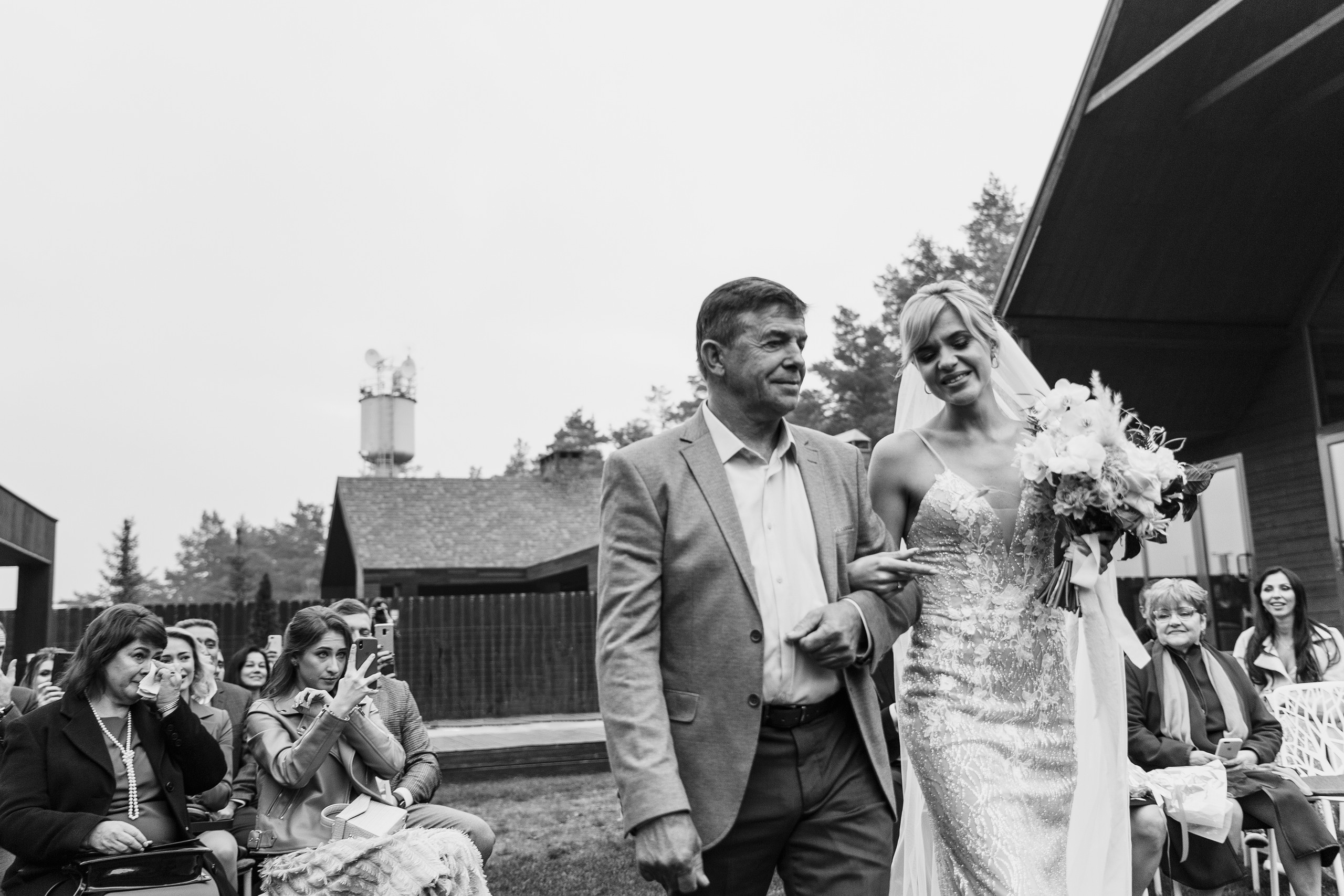 папа ведет невесту во время свадебной церемонии