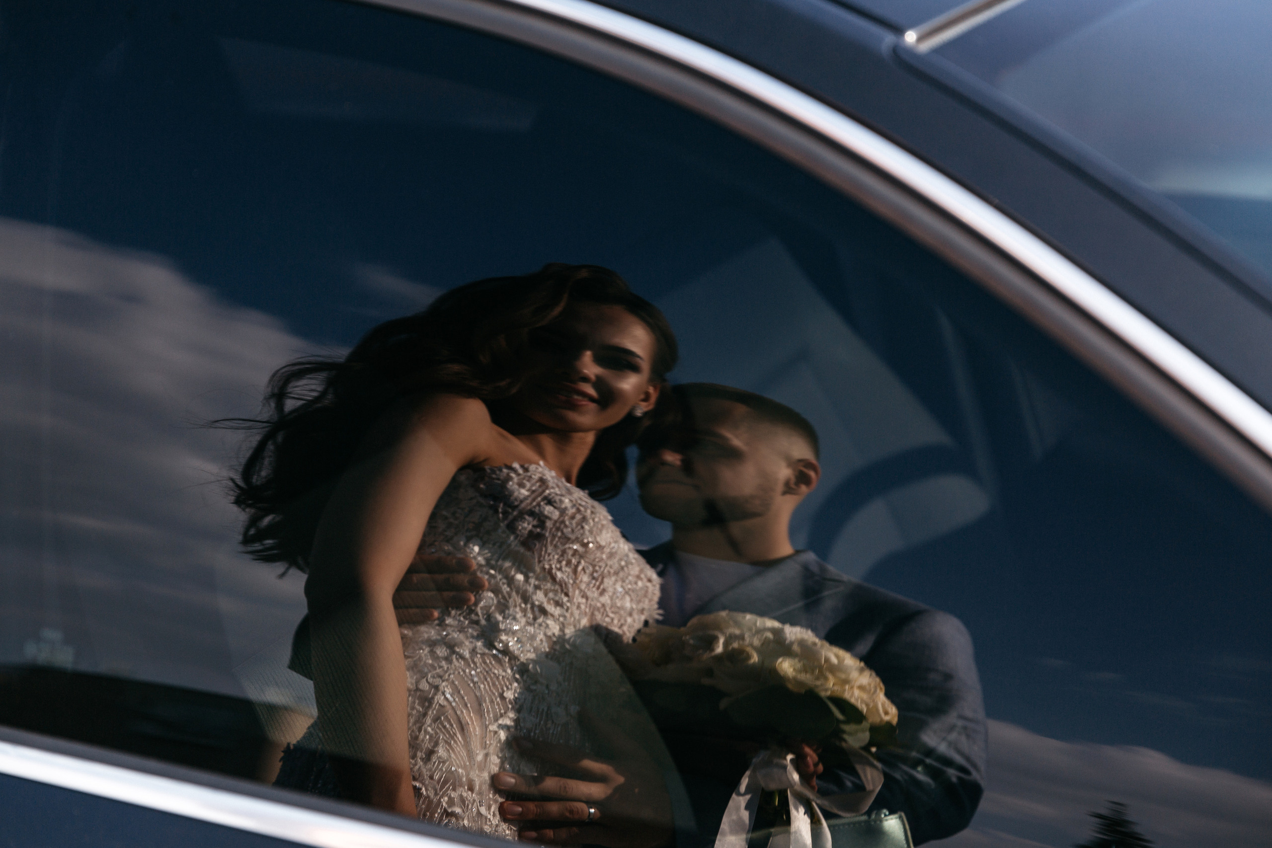 отражение жениха и невесты в машине