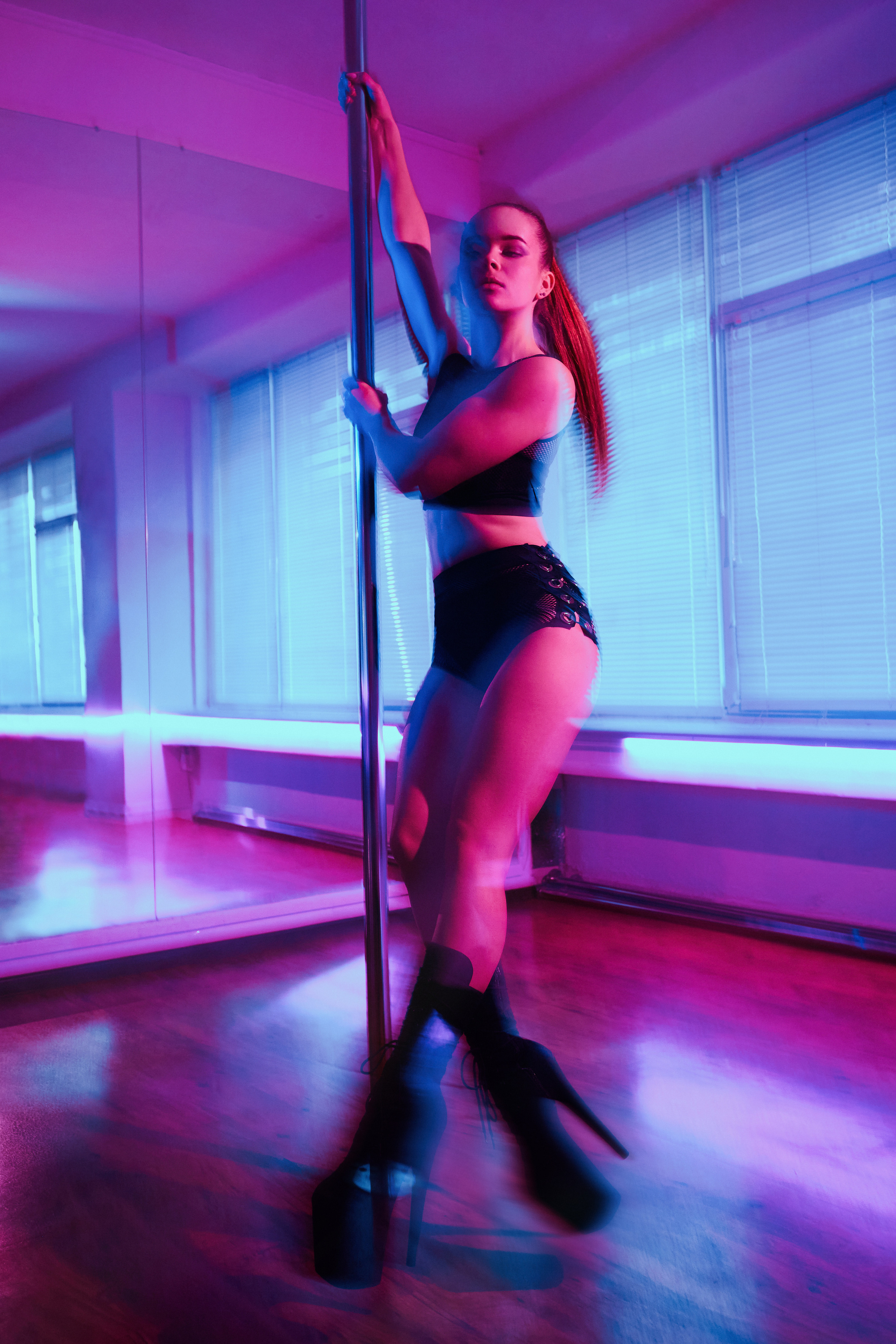 Яскрава кольорова зйомка танцівниці на пілоні, Pool Elegance стиль.