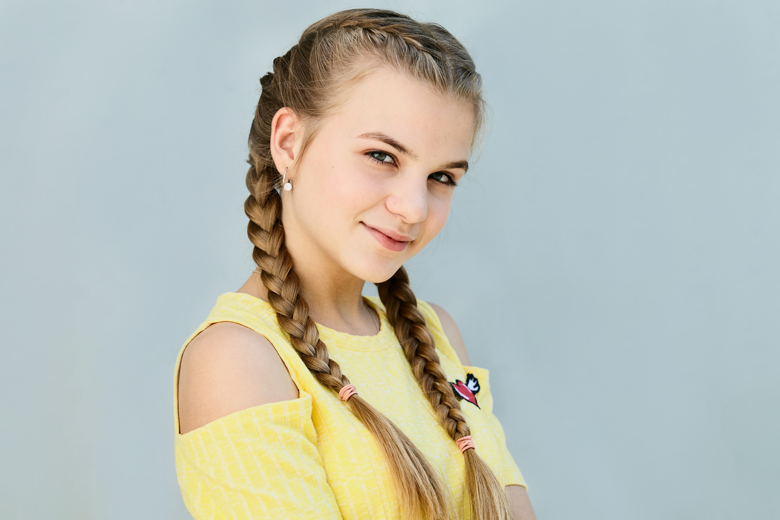 Молода дівчина в жовтій сукні на голубому фоні