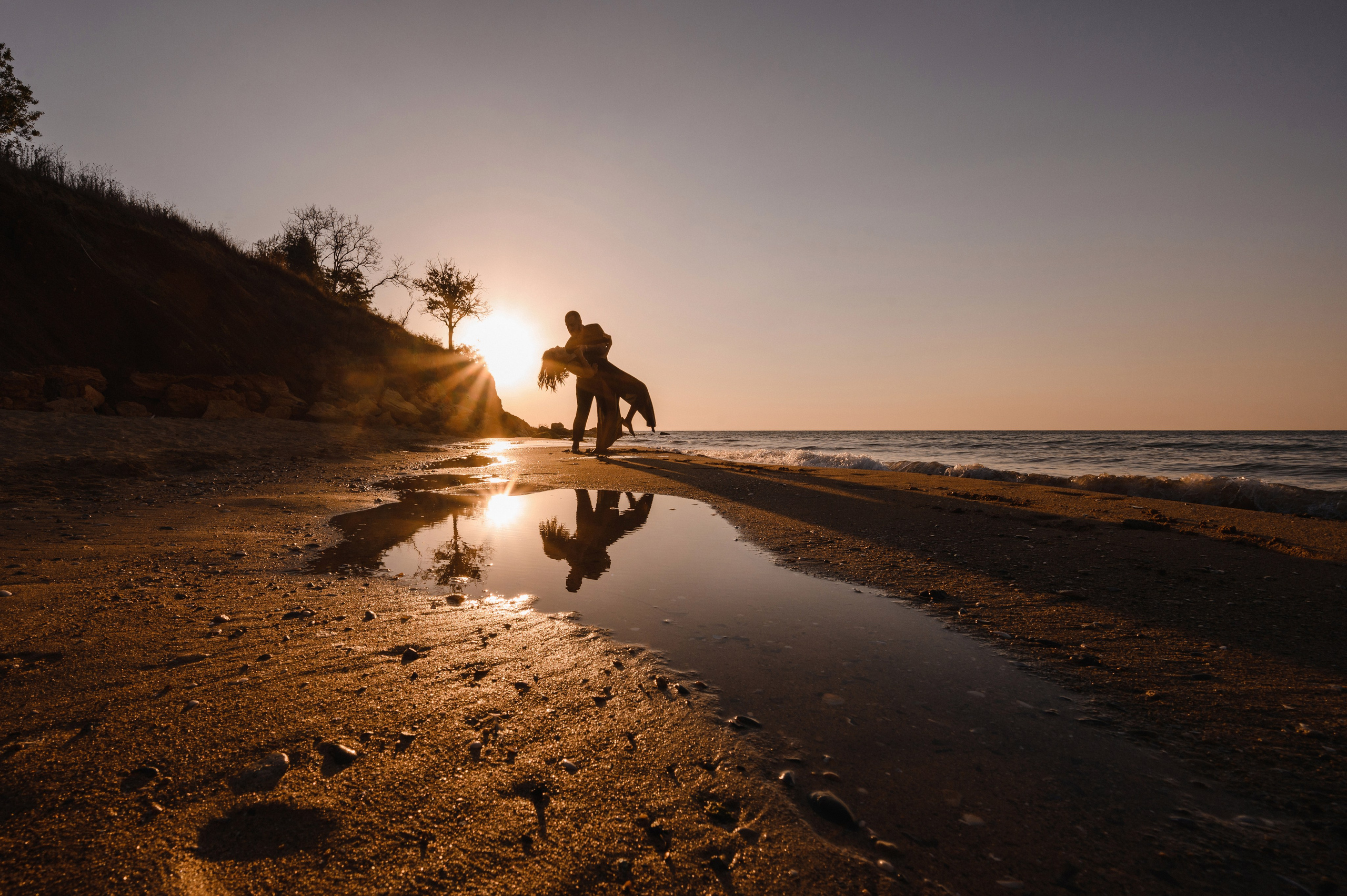 Морской рассвет на пляже с камнями