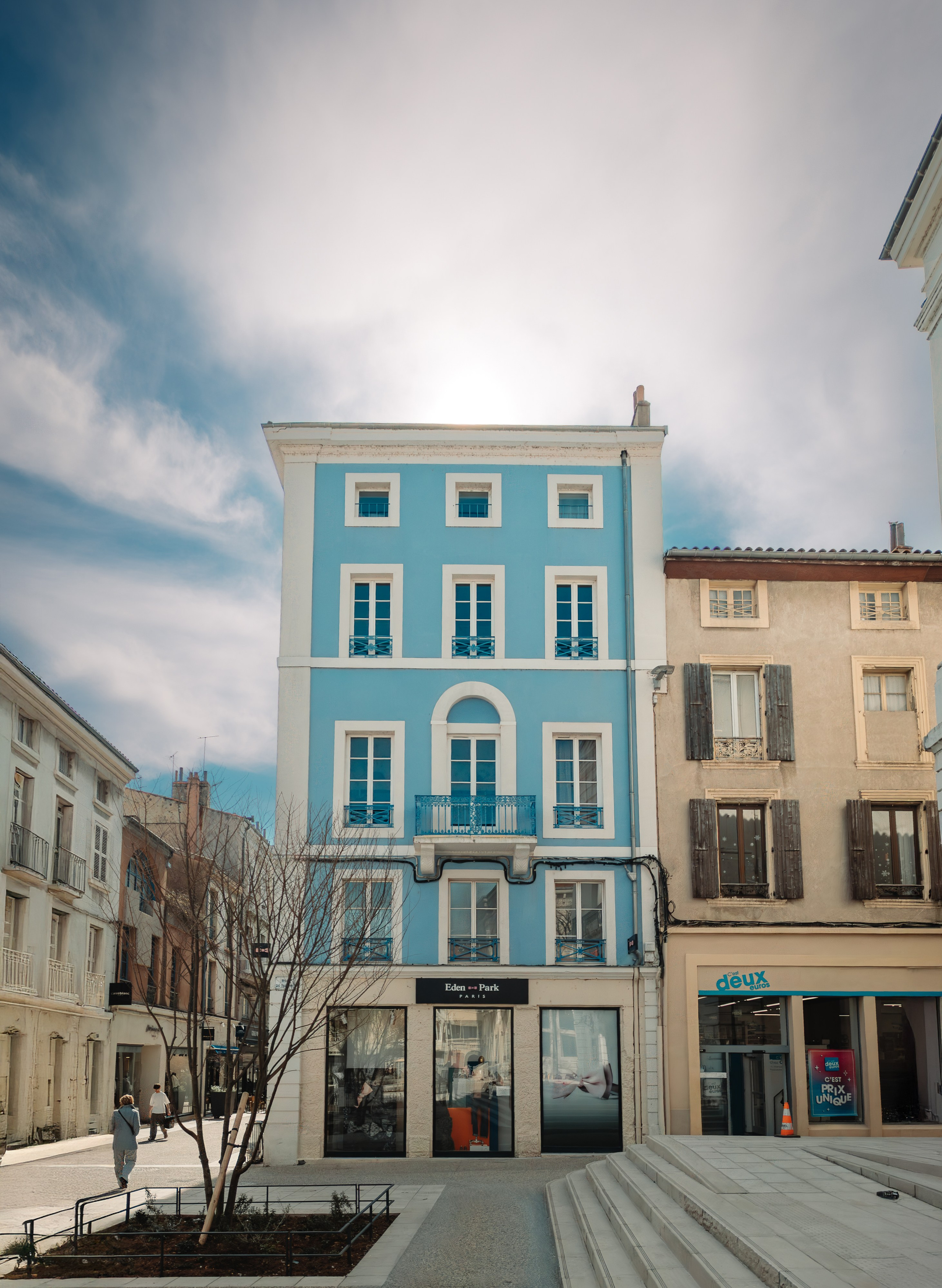 Blue and white urban building in Valence with balconies and architectural detail