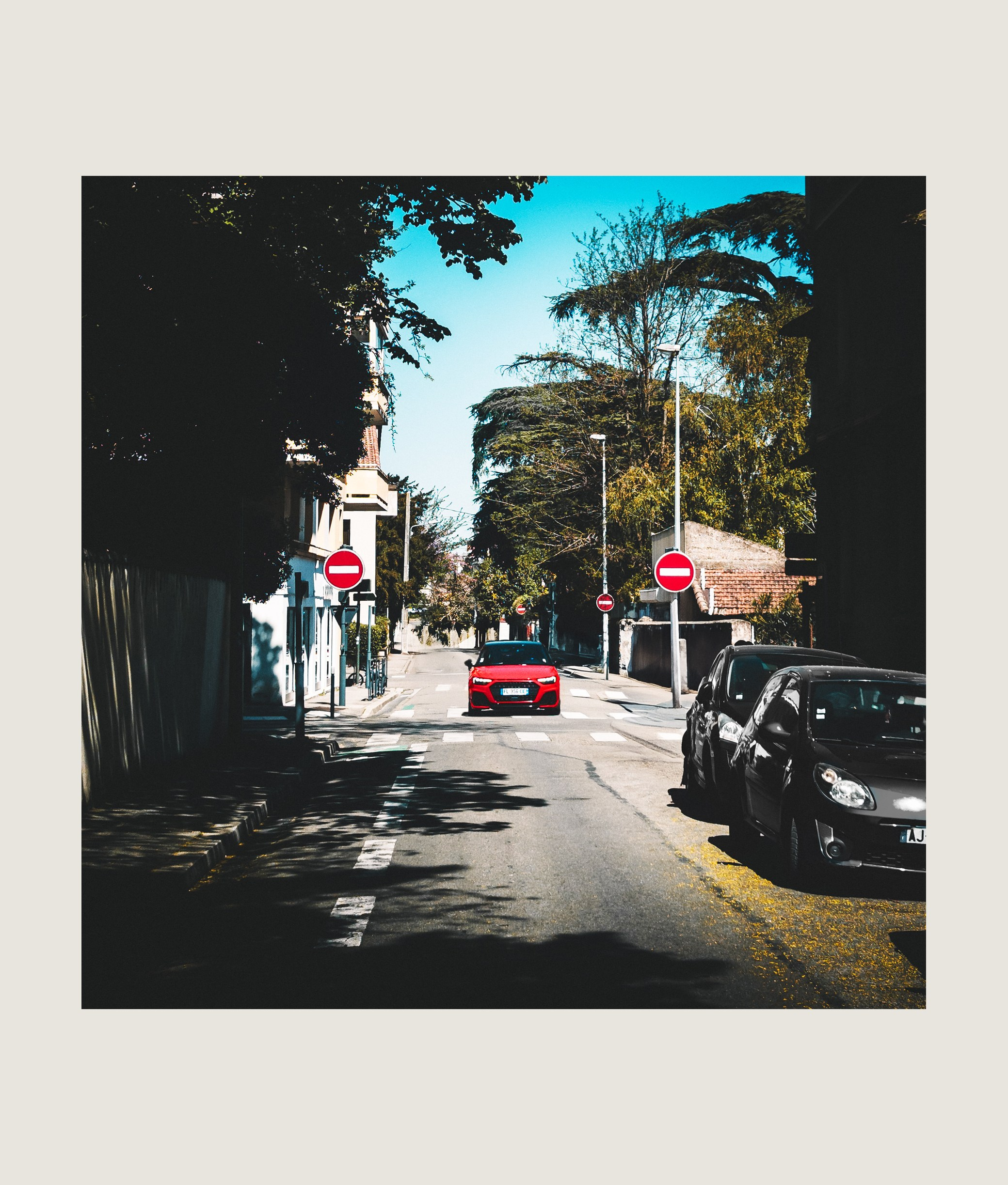 Valence street with parked cars, palm trees, and summer sunlight