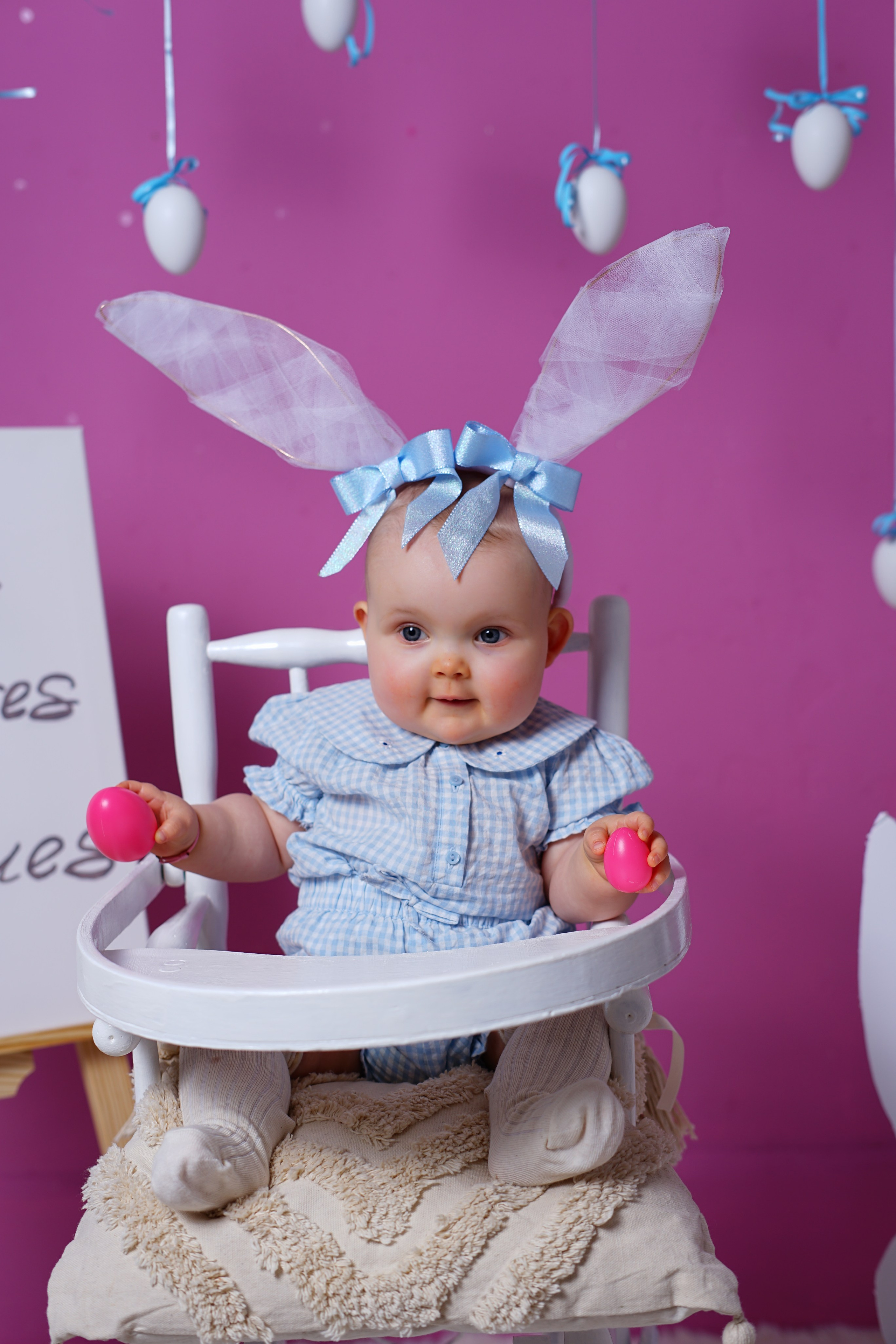 Séance photo bébé à Roanne – bébé souriant avec des oreilles de lapin sur fond rose.