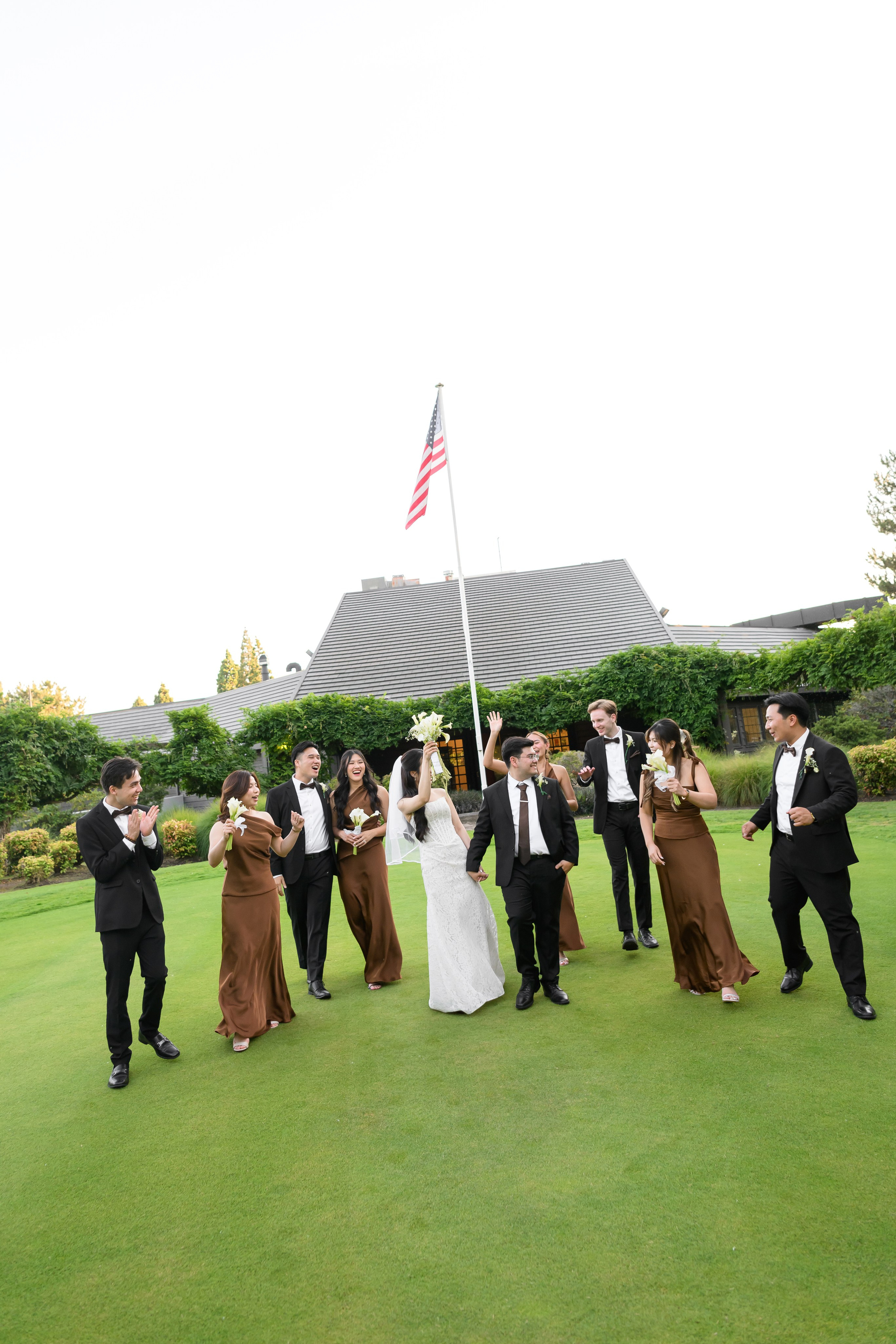 Wedding party celebrating with the bride and groom on the lawn