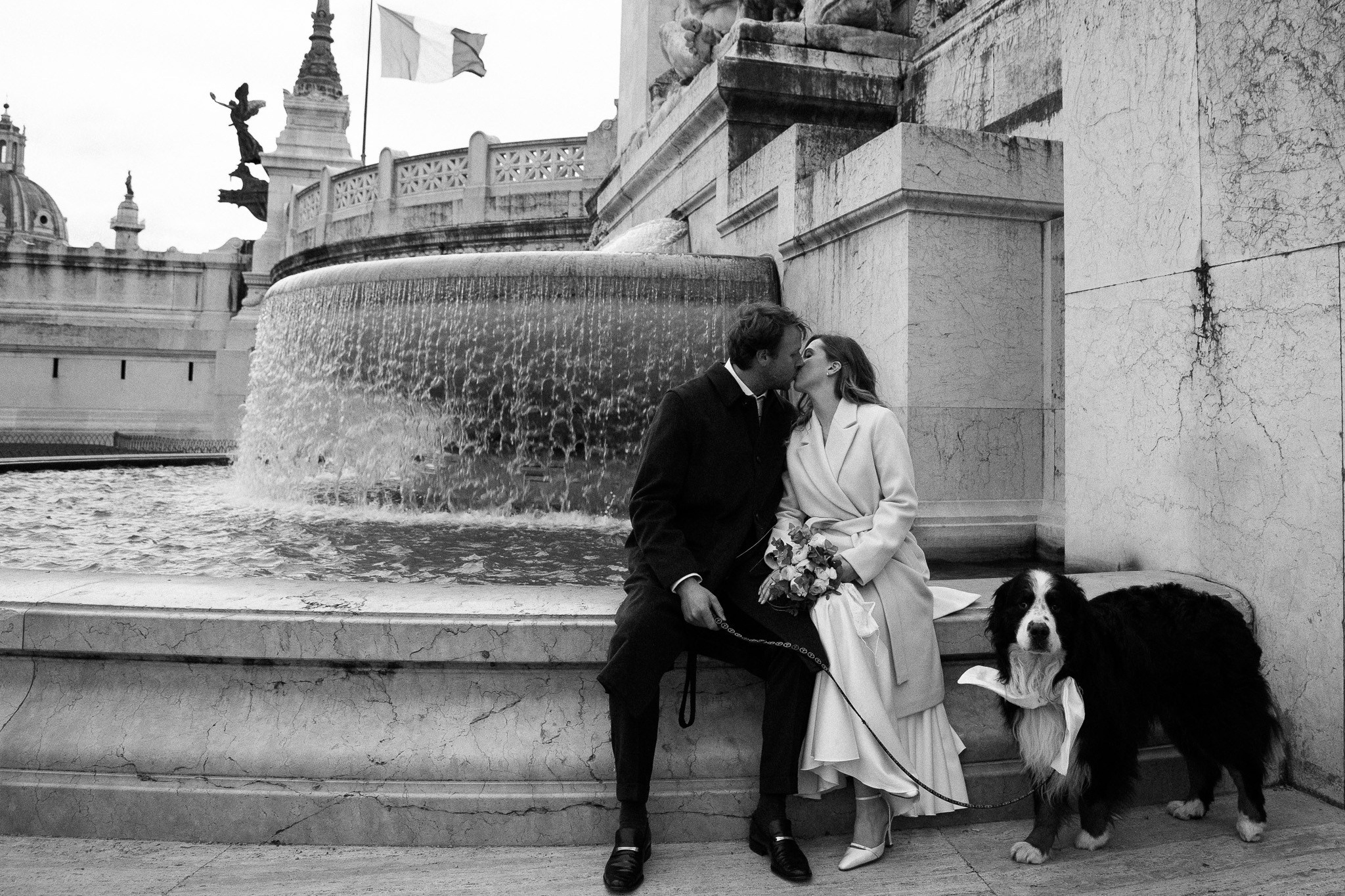 A just-married couple sharing a quiet moment with Rome’s Piazza Venezia in the background.